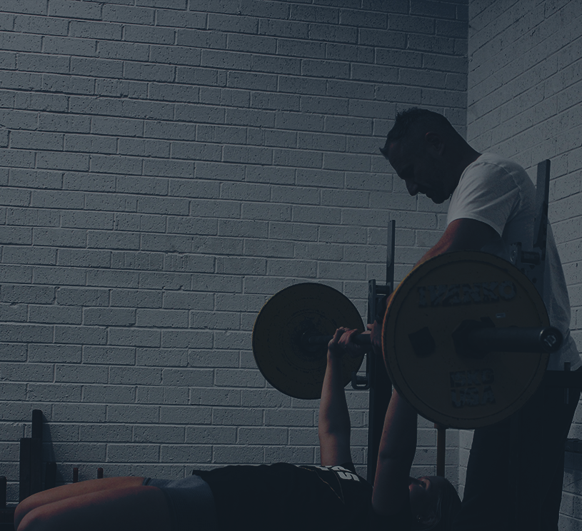 coach with client bench press