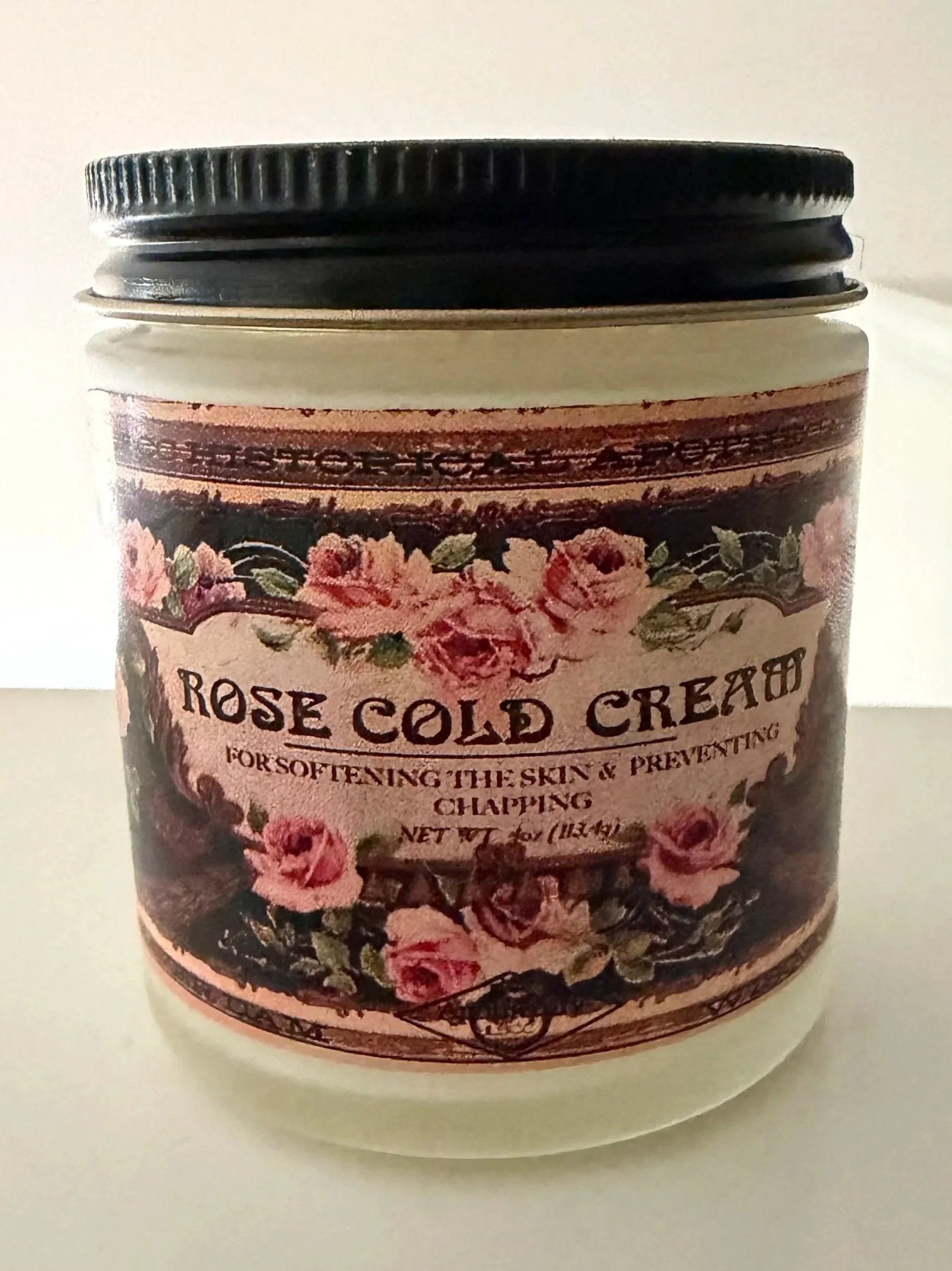 Close-up of a jar of rose cold cream with a vintage-style floral label.