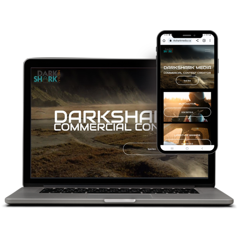 Laptop and smartphone displaying the DarkShark Media commercial content creator website, featuring a landscape background and menu options.