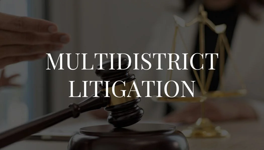Gavel and a scaled legal balance on a lawyer's desk, with a superimposed text reading 'Multidistrict Litigation'.