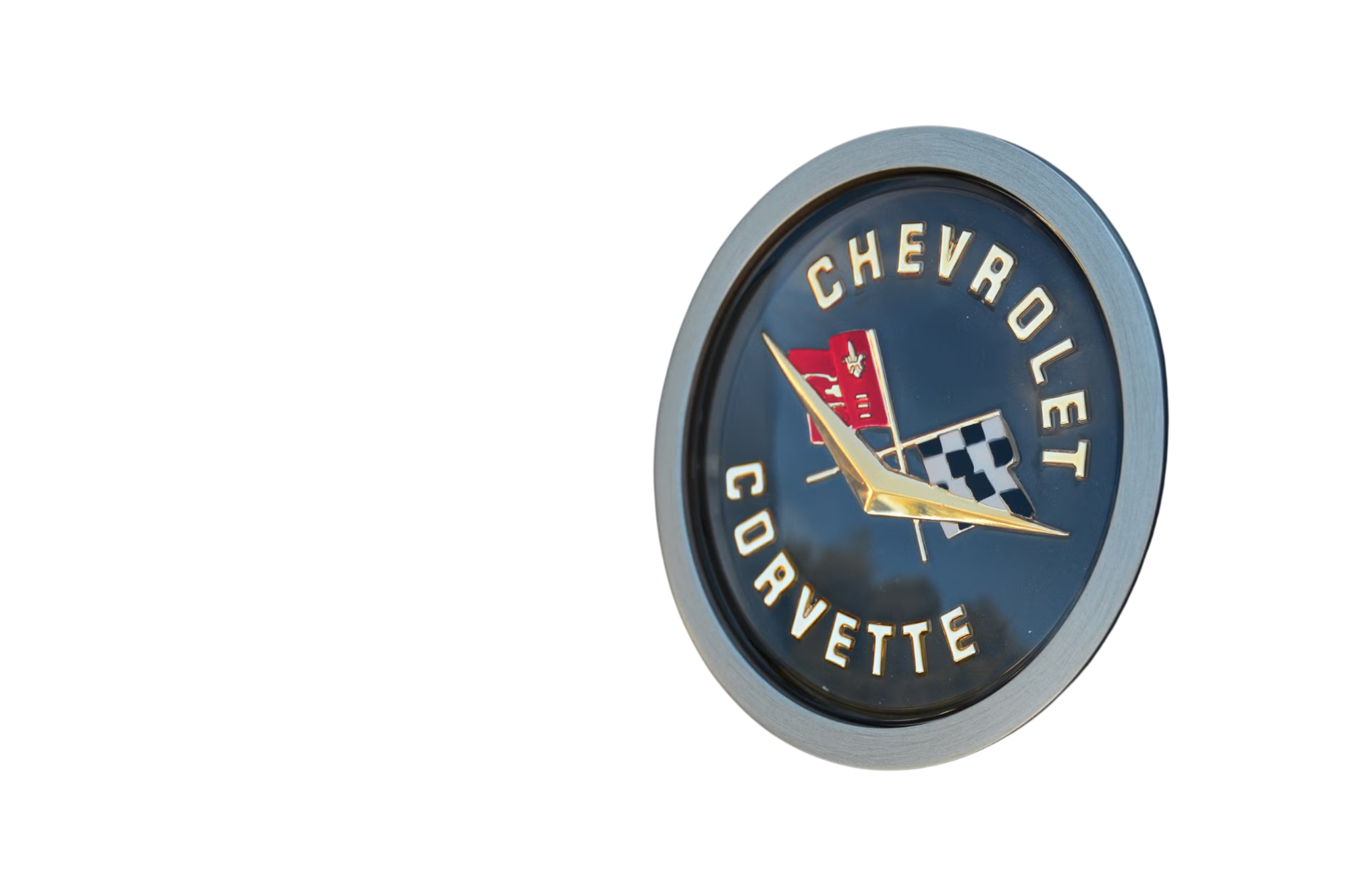 Close-up of a vintage Chevy Corvette clock with a Chevrolet logo and checkered flag emblem, showing the time as approximately 4:55.