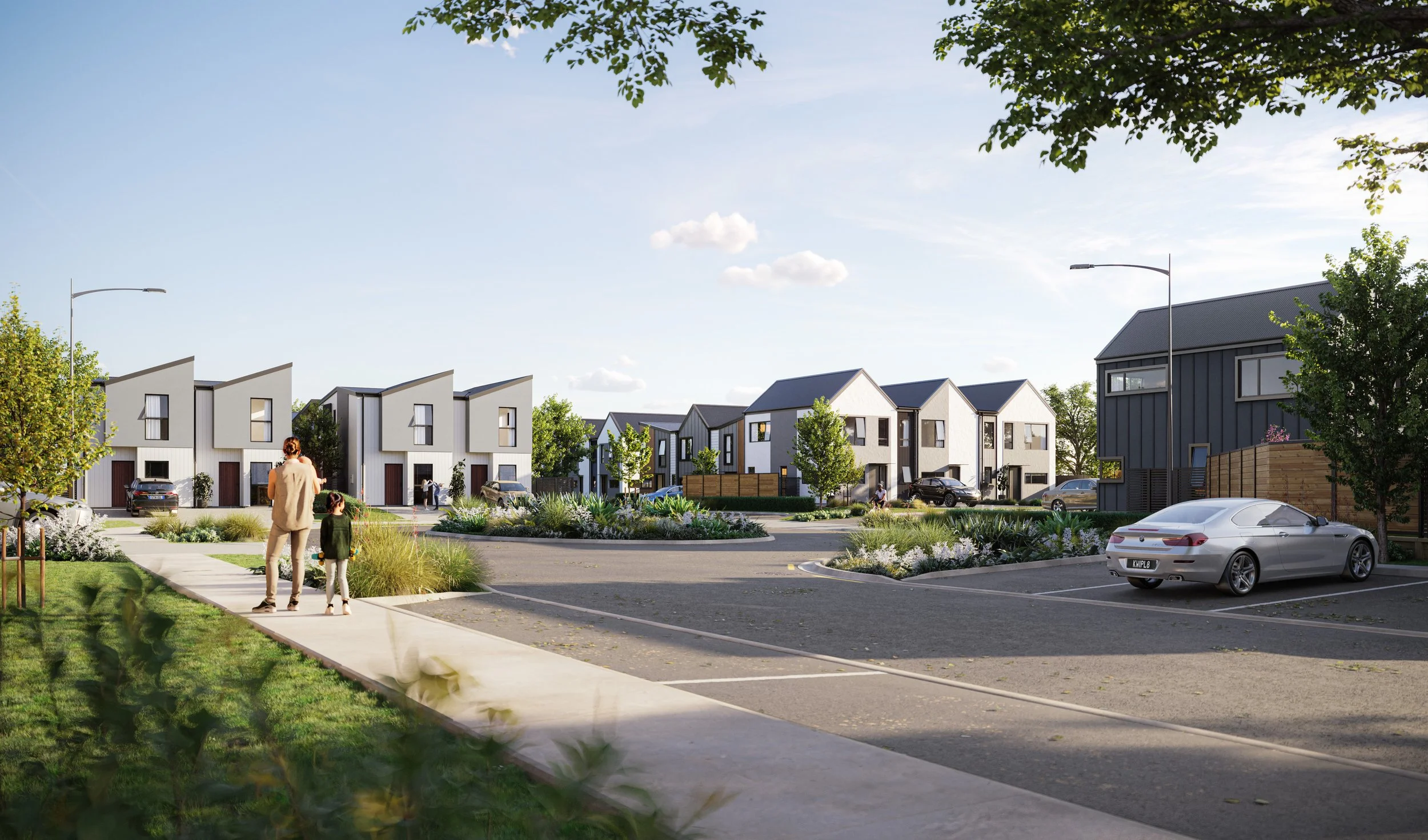 Trackside's modern residential neighbourhood with multiple contemporary townhouses, landscaped green spaces, and parked cars, viewed on a clear day with a blue sky offers first home buyers and families a community they can thrive in.