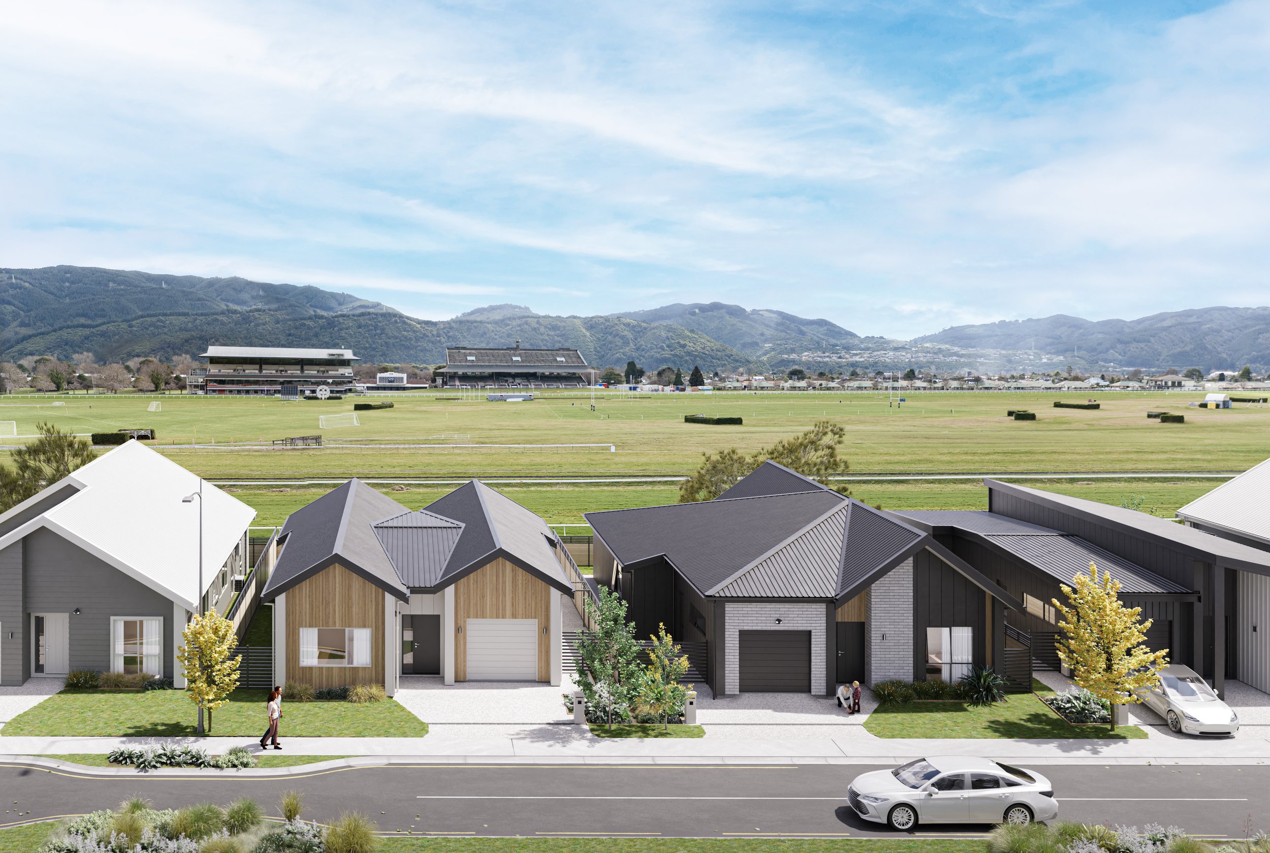 A render of Back Straight, a development by Gillies Group, shows a row of modern suburban houses with front yards and trees, street with parked cars, and expansive green sports field with distant hills in the background.