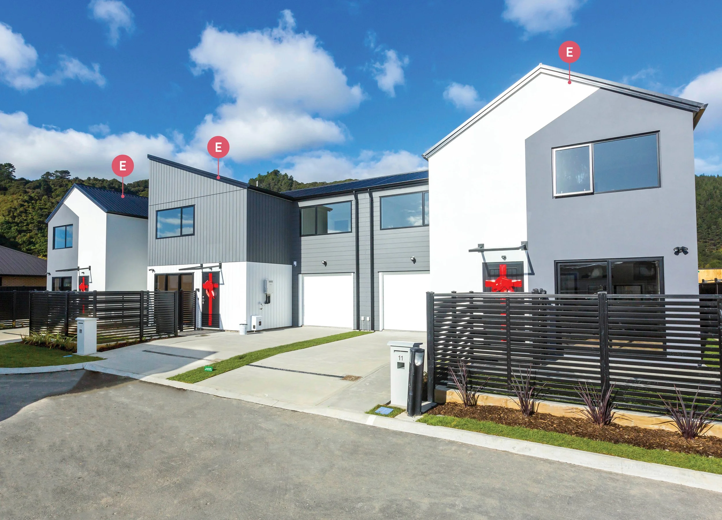 Three Type E homes with enclosed yards and white and grey exterior colouring, located in Wallaceville Estate's The Reserve: Final Release, a development by Gillies Group