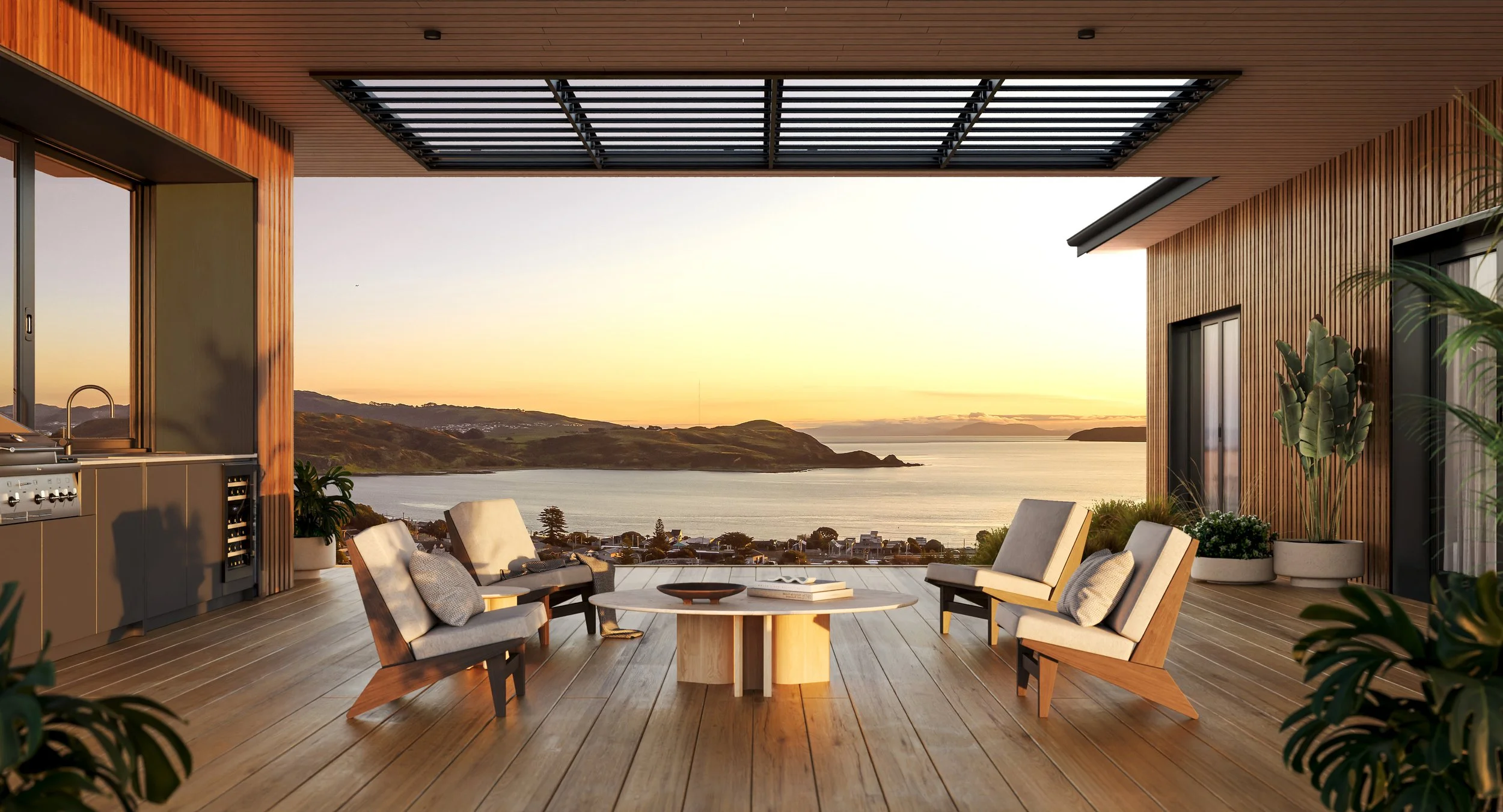 Modern outdoor patio with wooden flooring and furniture, overlooking a bay with mountains at sunset, featuring a table, chairs, and potted plants, a great example of the Plimmerton Heights potential for those looking to build their forever home