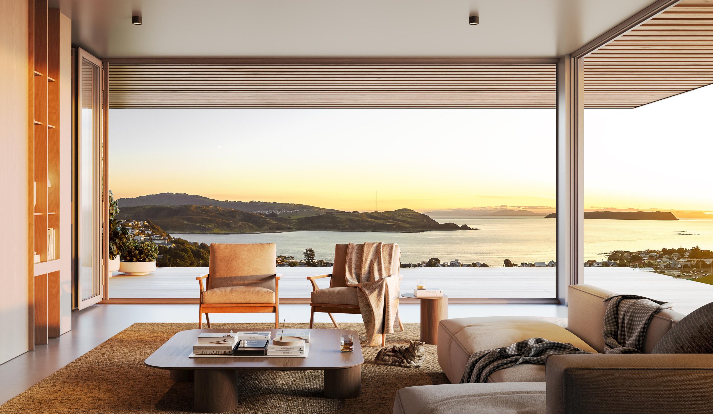 A render of a Plimmerton Heights living room with large glass windows overlooking a sunset over water and hills, beige couch with blanket, wooden chairs, coffee table with books and drinks, and a cat lying on the floor.