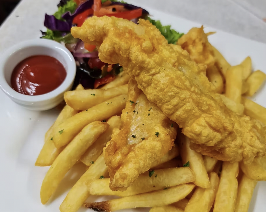 Fried fish fillet with French fries, side salad, and ketchup on a white plate.