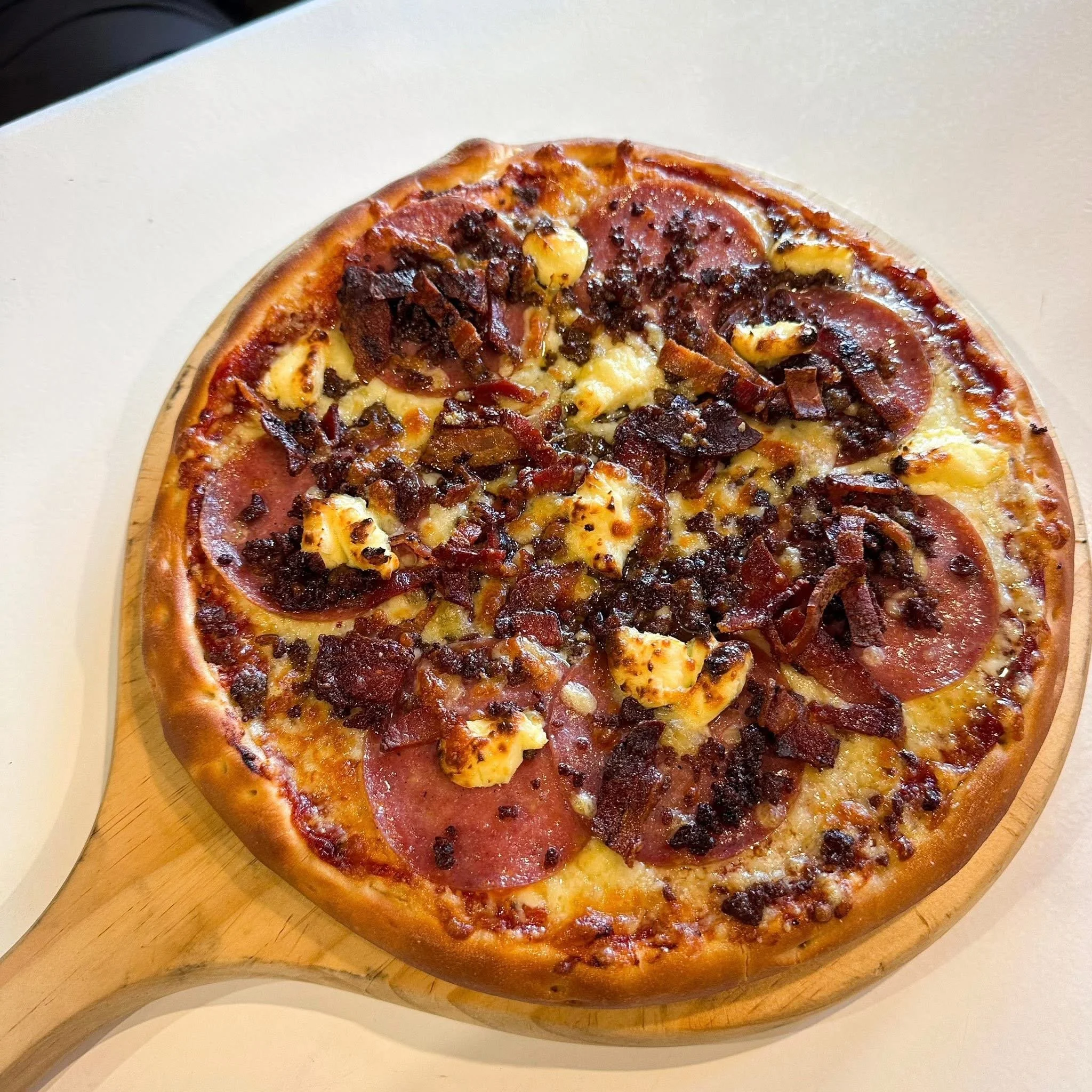 Pizza with pepperoni, bacon, chicken, and cheese.