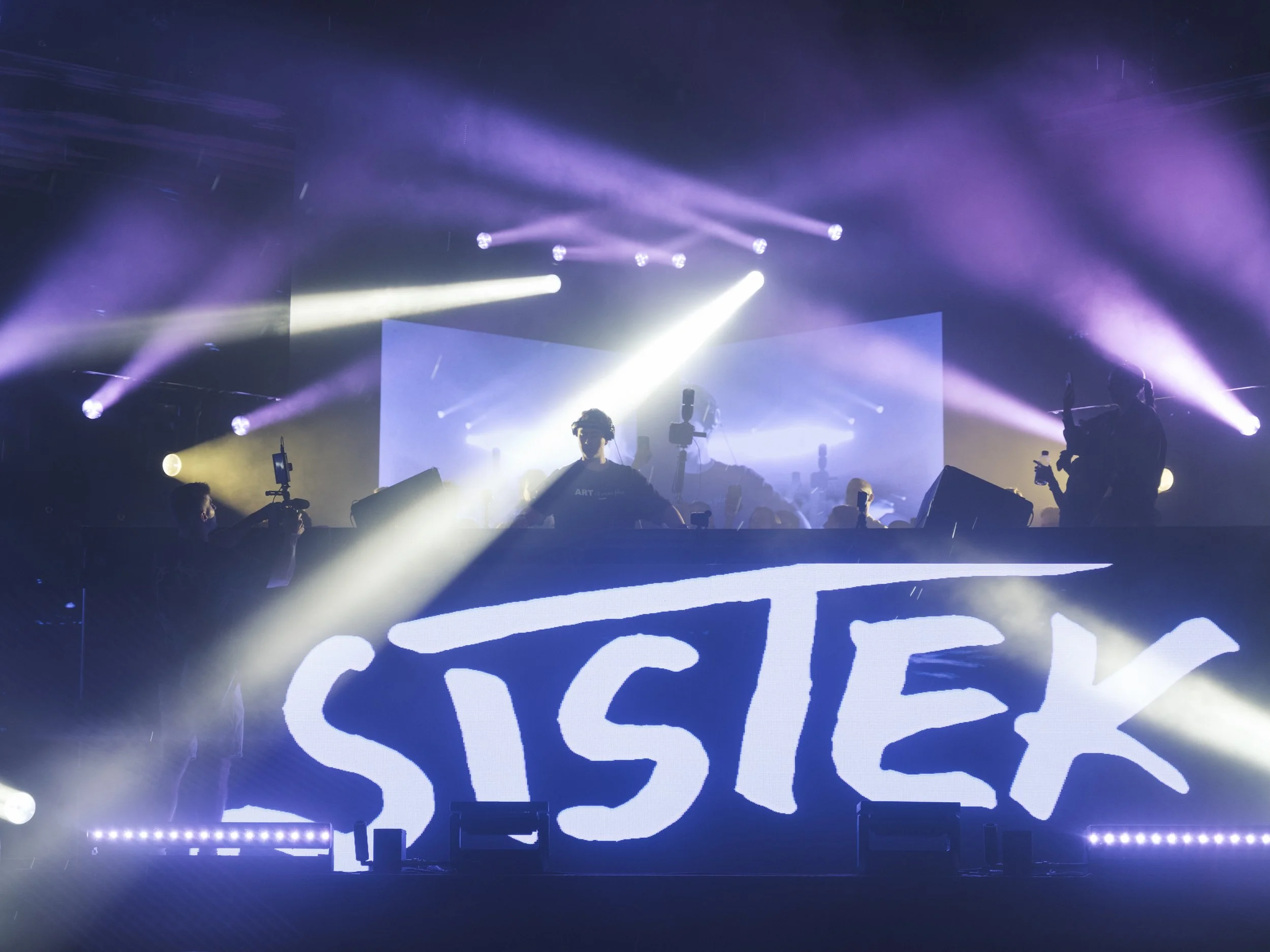 Bright stage graphics and audience silhouettes photographed during Unity Electrofëst