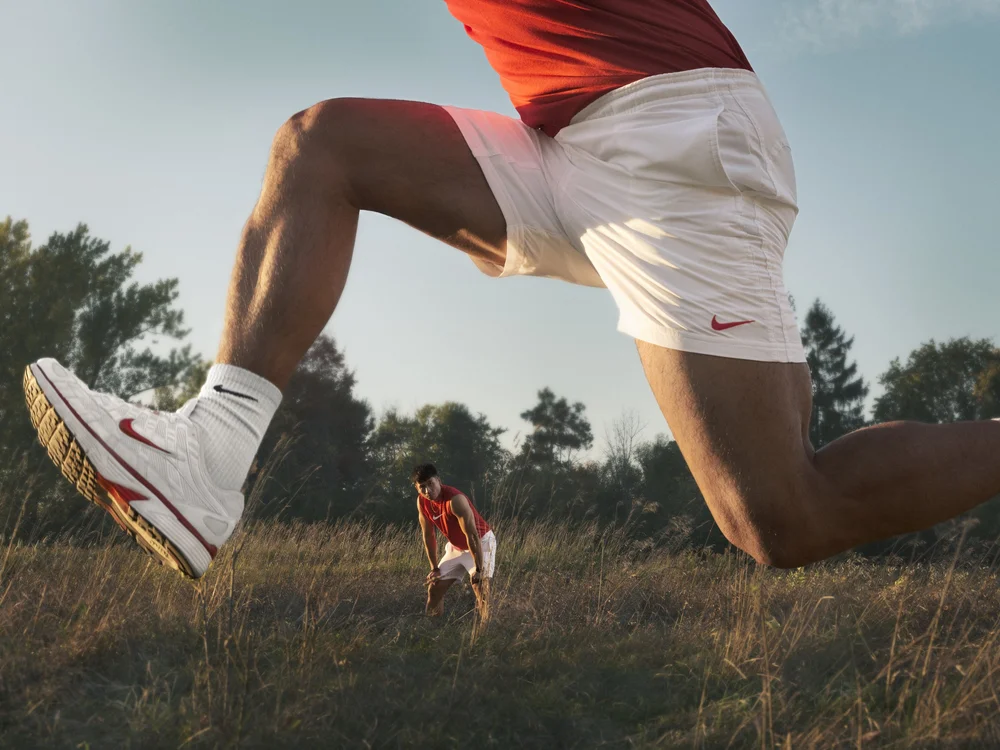 Sportswear fashion campaign photography featuring athlete jumping outdoors at sunset