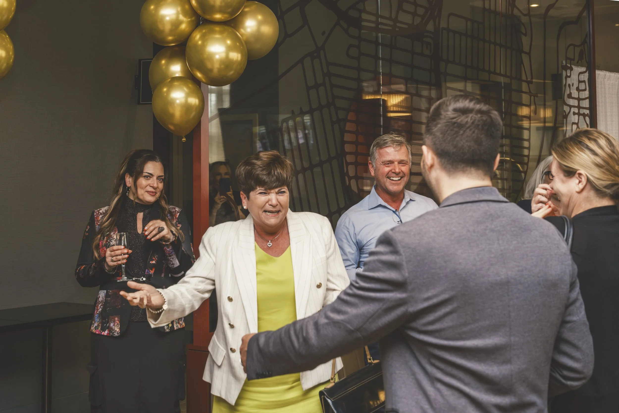 Guests posing together during Mirella retirement party in a warm event setting