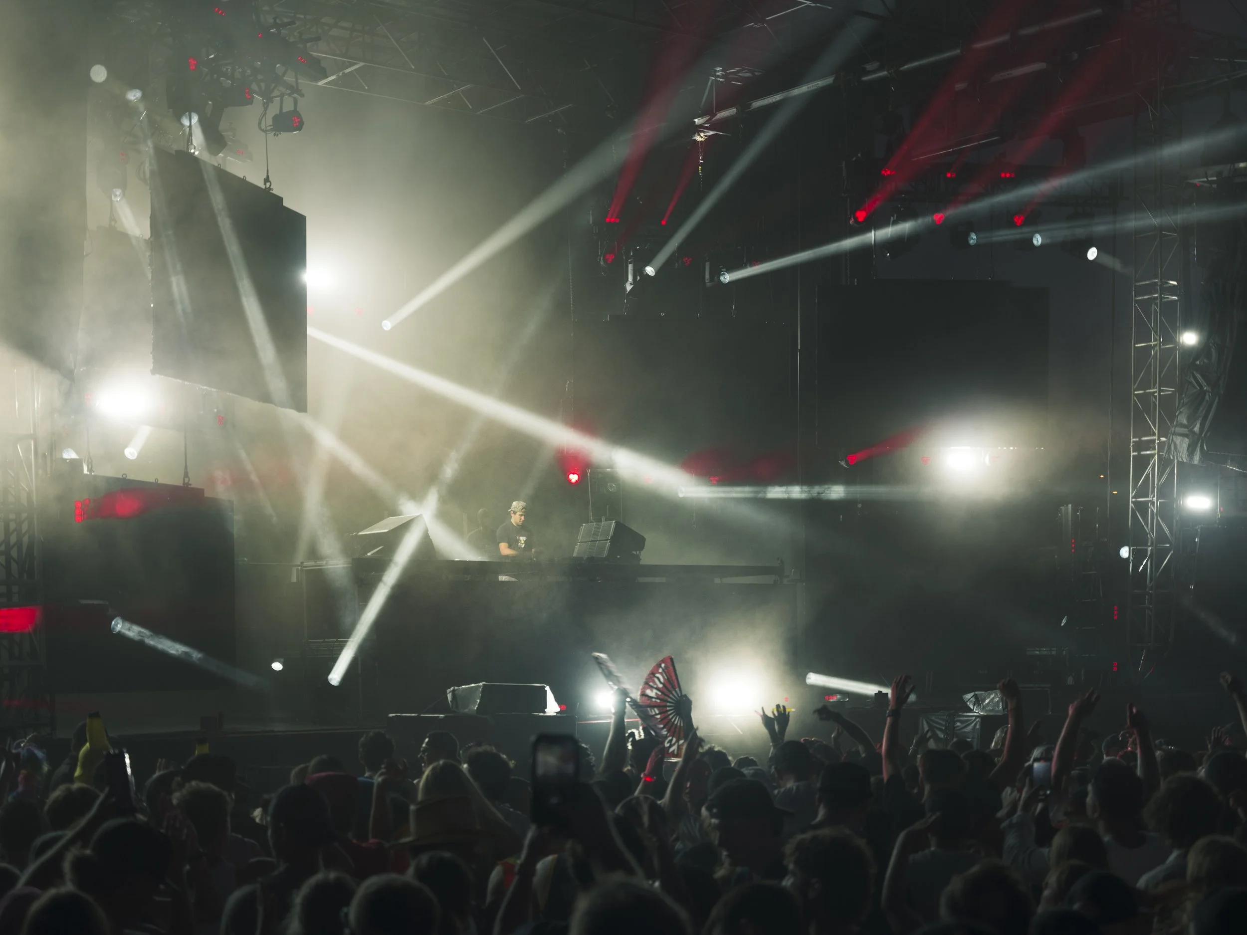 Unity Electrofëst stage photographed with smoke, yellow light, and a crowd in front of the performance