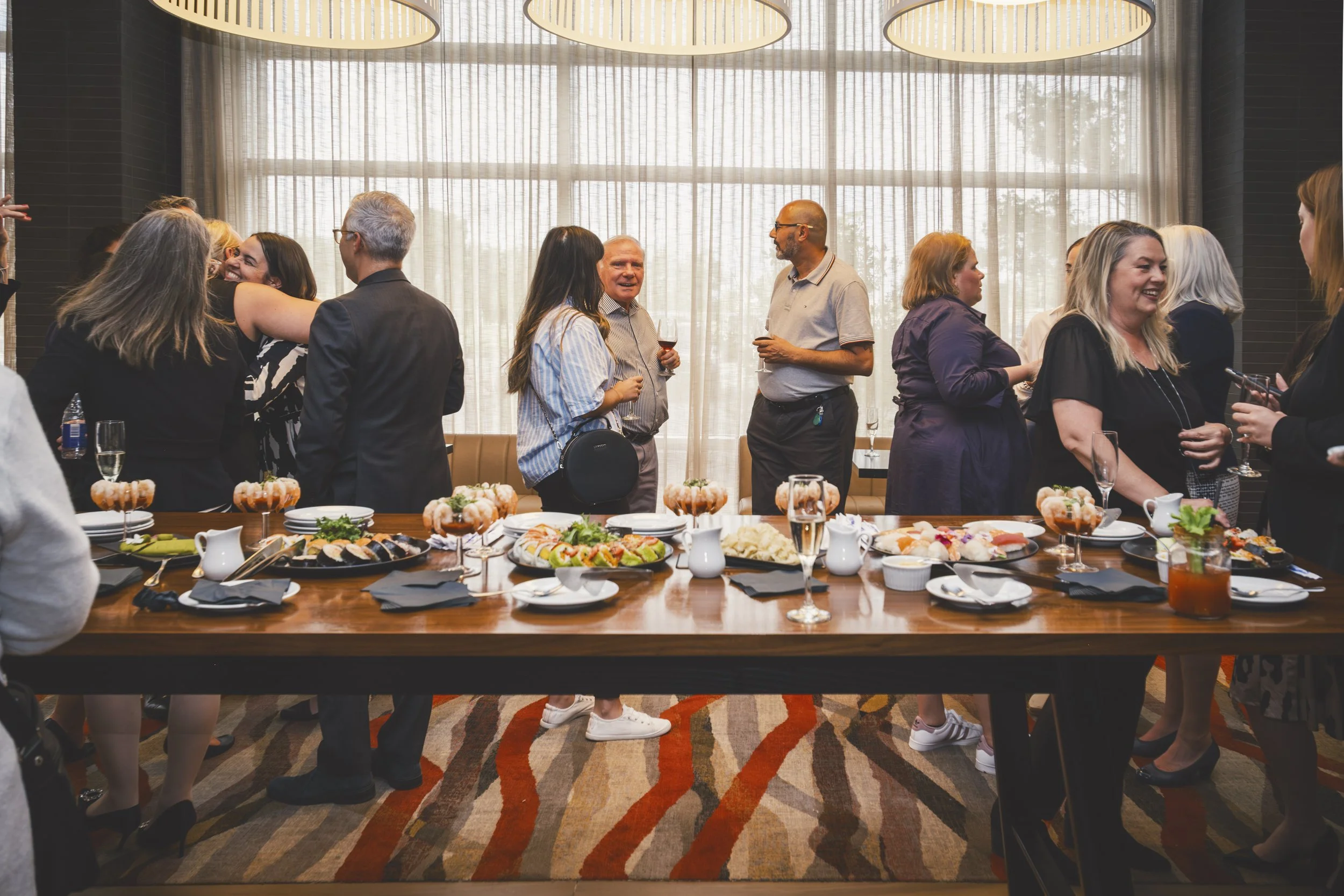 Guests enjoying food and conversation during Mirella retirement celebration