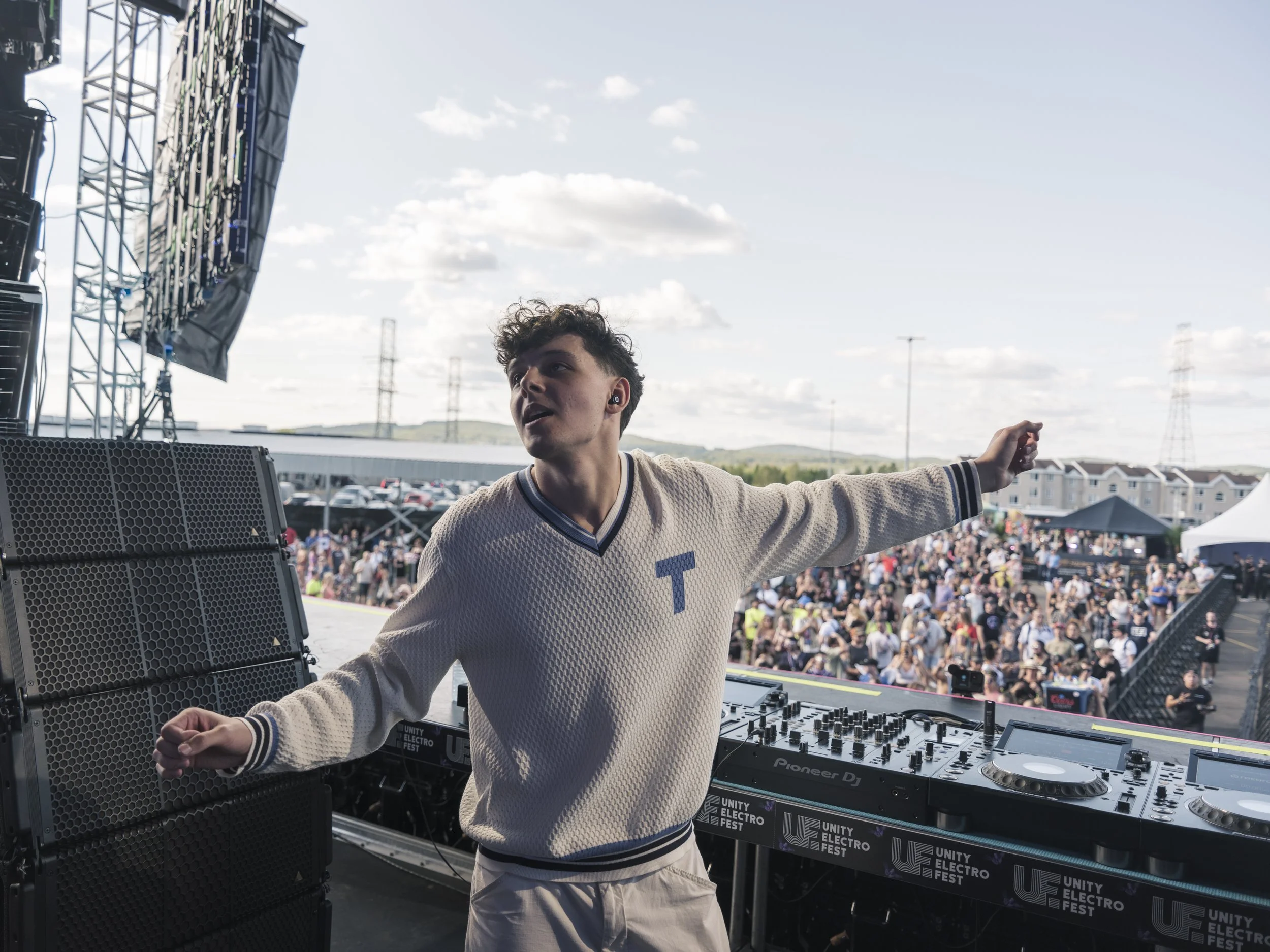 Performer standing on stage while looking out over the festival crowd at Unity Electrofëst