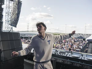 Performer standing on stage while looking out over the festival crowd at Unity Electrofëst