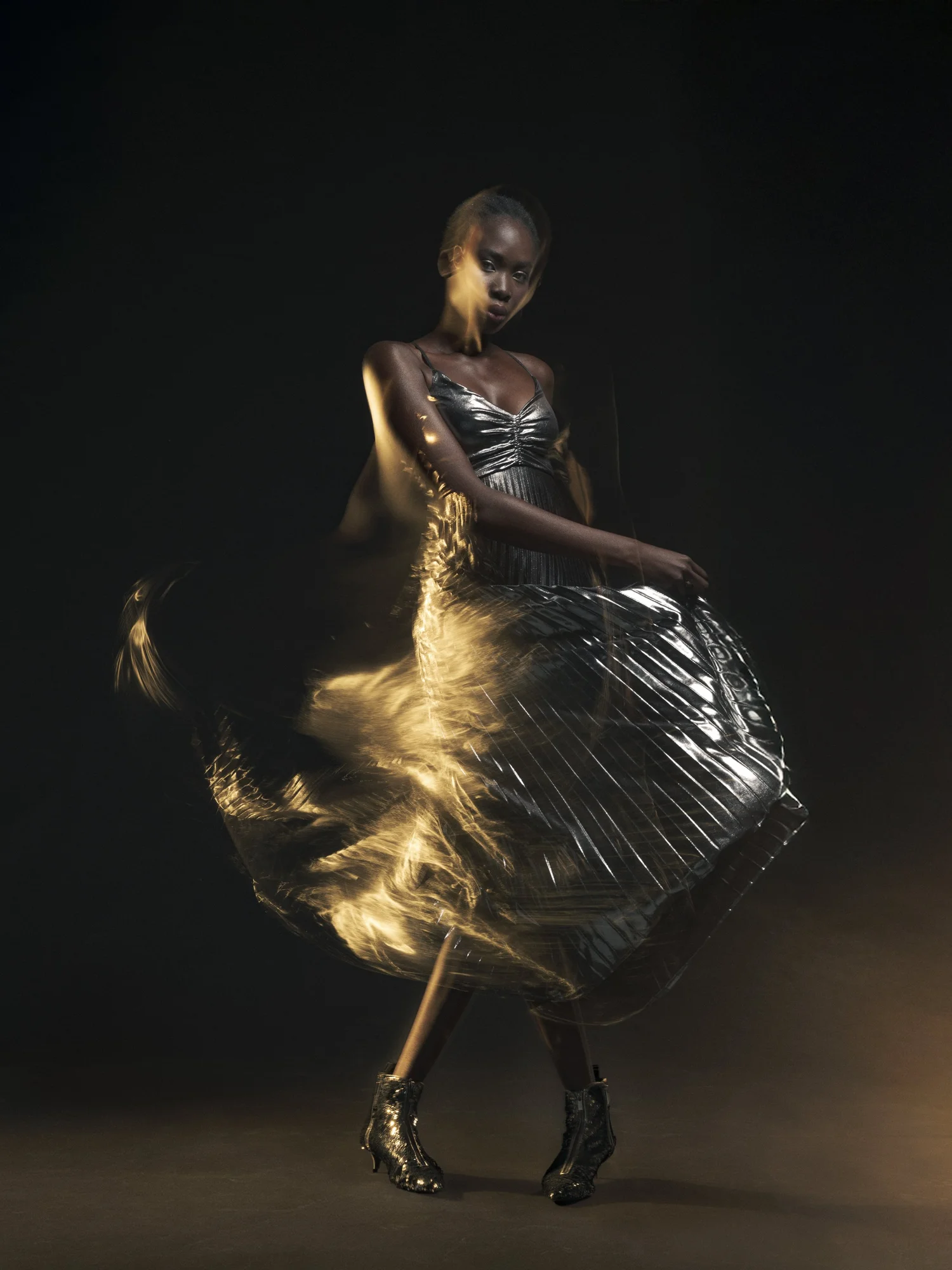 Studio fashion image with model in dark dress and dramatic motion blur