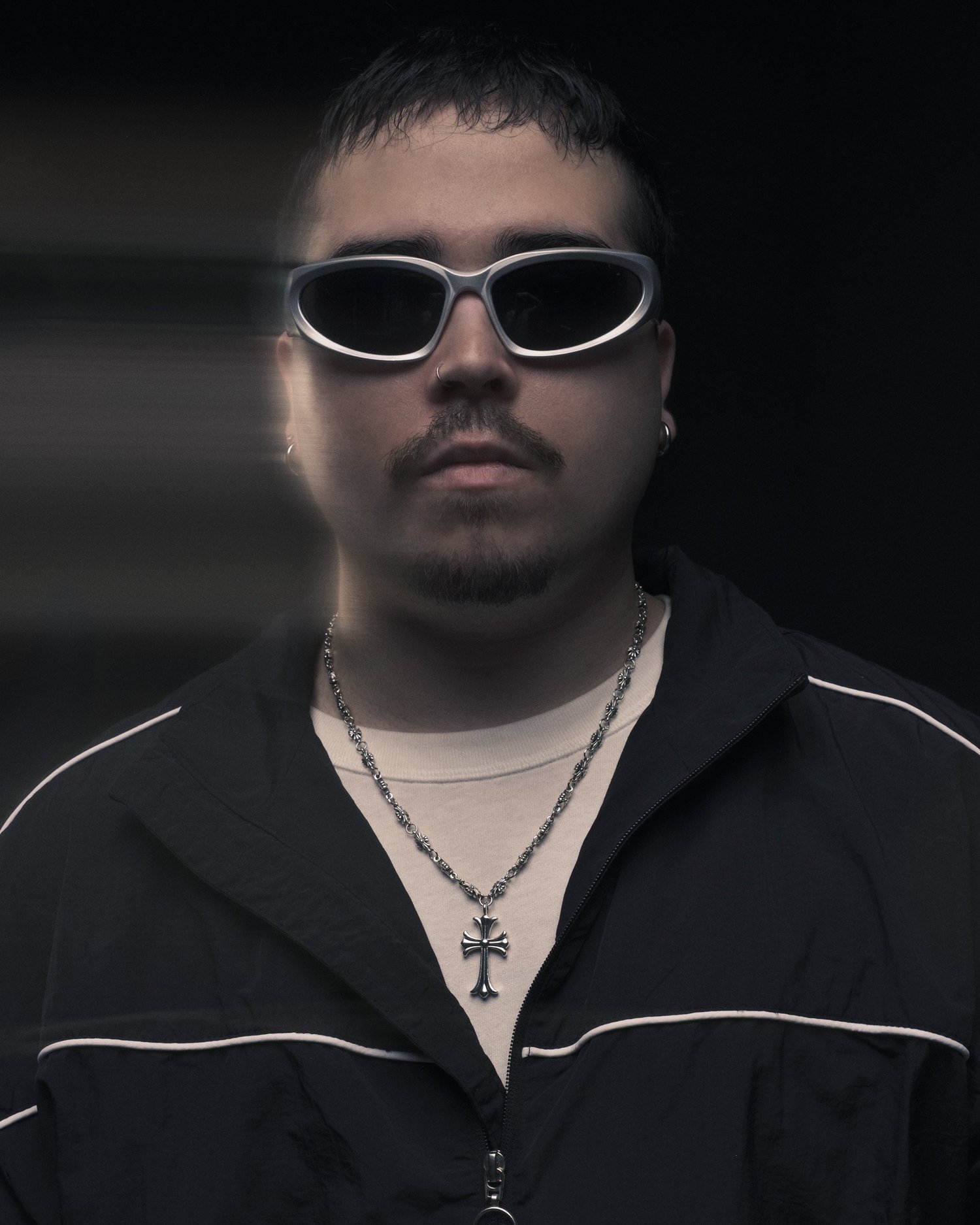 Studio fashion portrait with direct flash, sunglasses, and dark styling