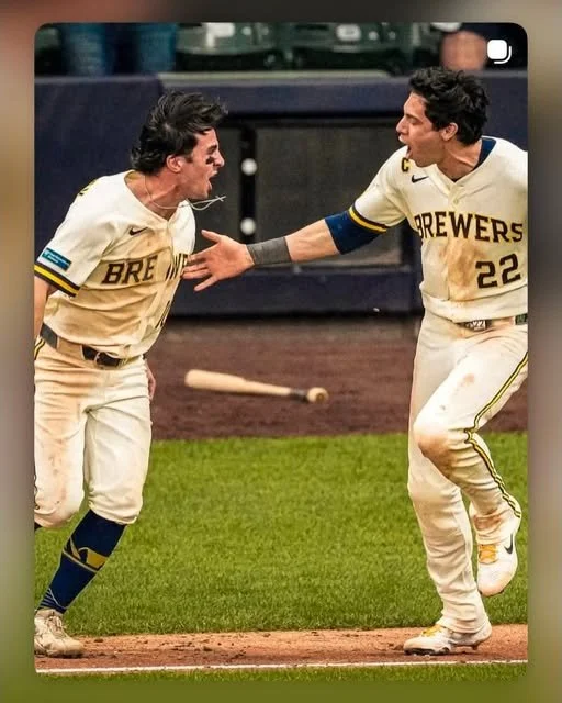 Players from the Brewers celebrate on the field.