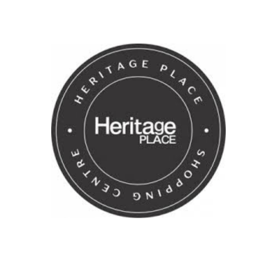 A circular logo with white text on a black background that reads 'Heritage Place Shopping Center' around the outer edge and 'Heritage Place' in the center.