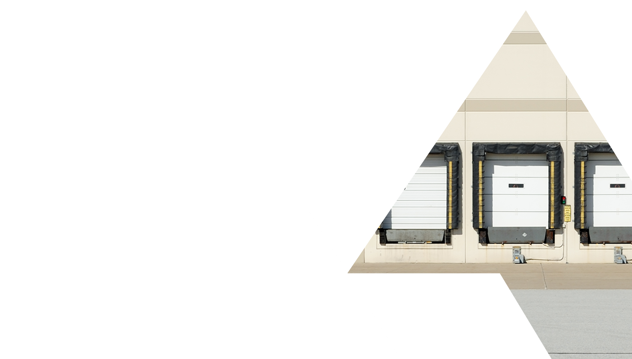 Industrial building with three garage doors, two of which are closed, one partially open, surrounded by black protective guards.