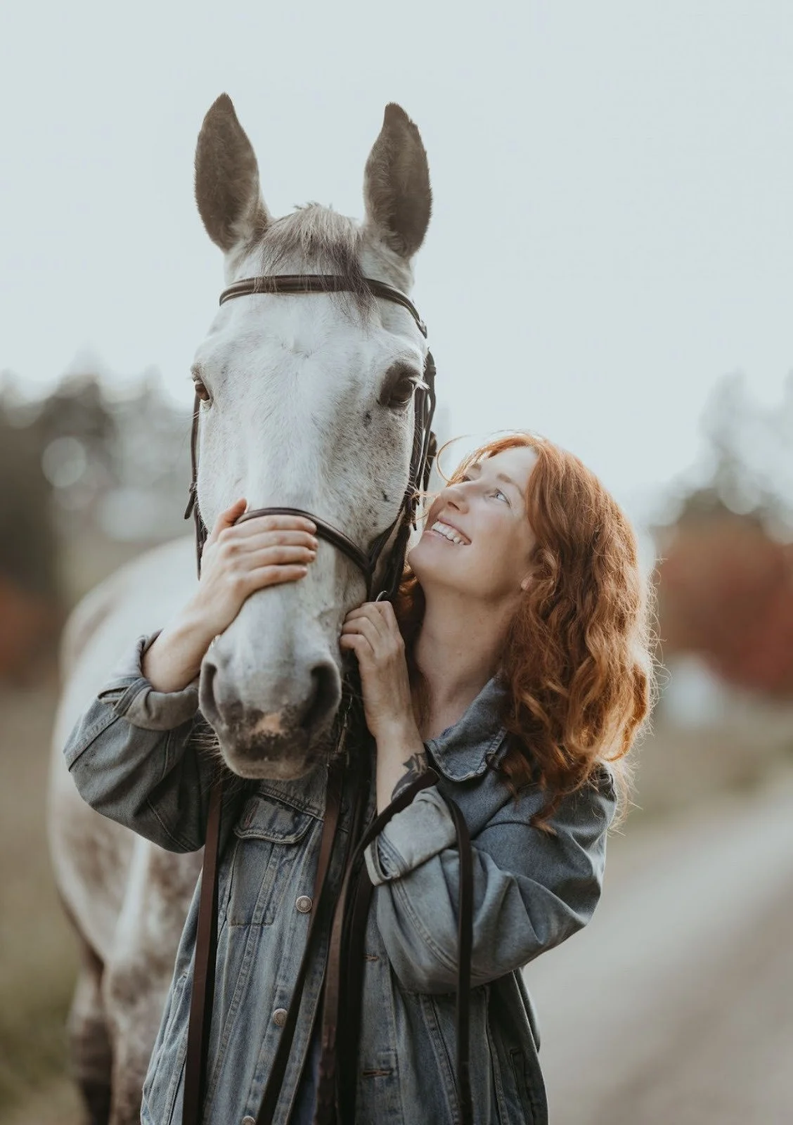 Red-headed woman with grey horse