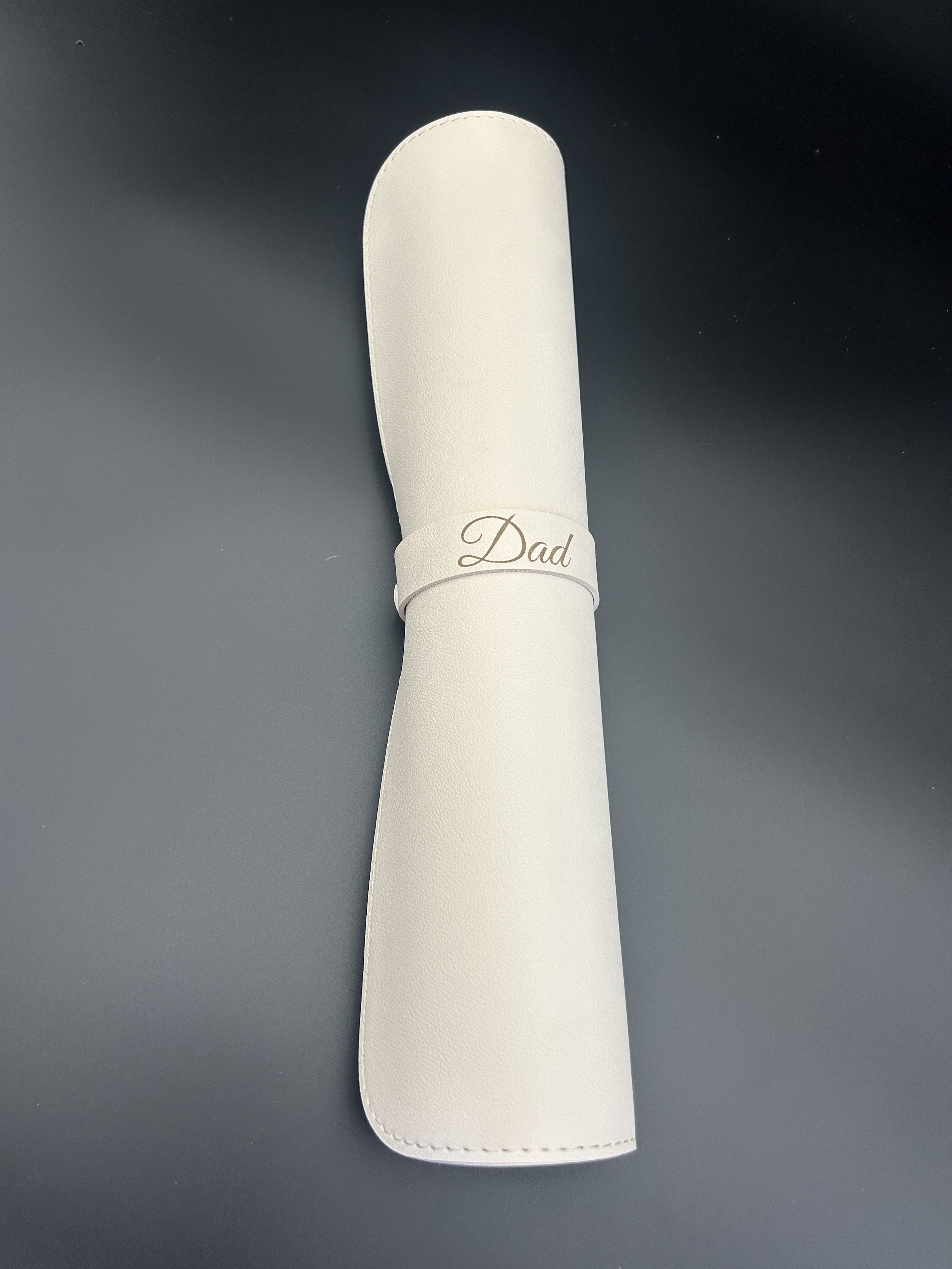 PU leather desk mat rolled up showing 'Dad' engraved leather tag