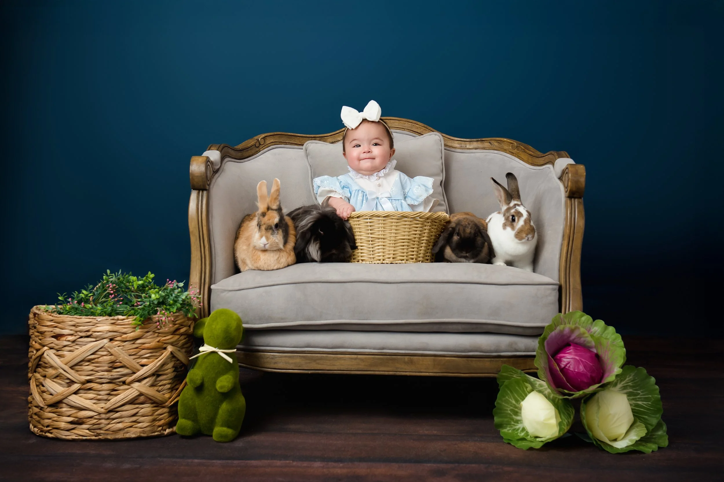 Baby girl in pastel dress sitting with bunnies during San Antonio bunny session