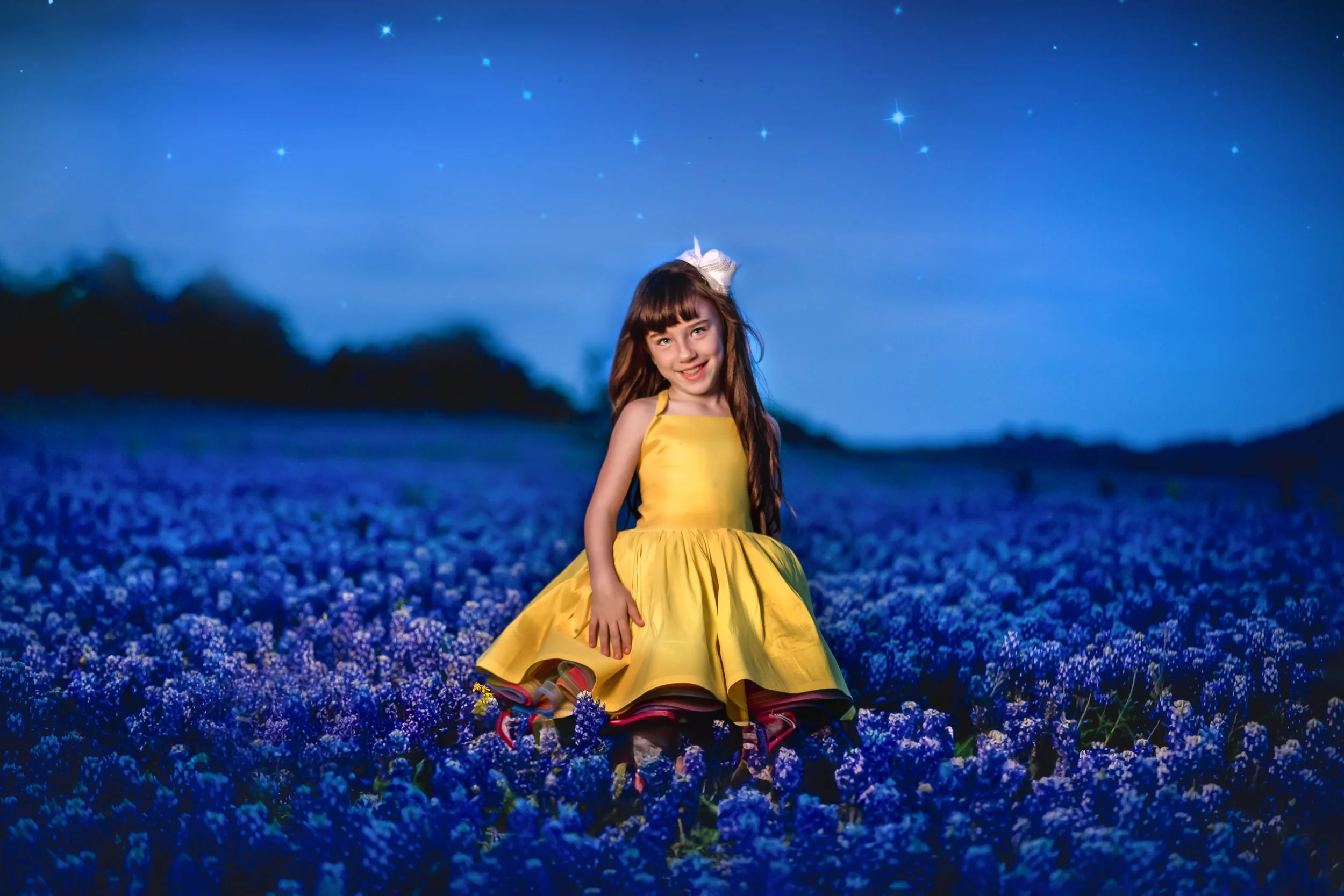 A young girl in a yellow dress sitting in a field of purple flowers at night, with a starry sky above.