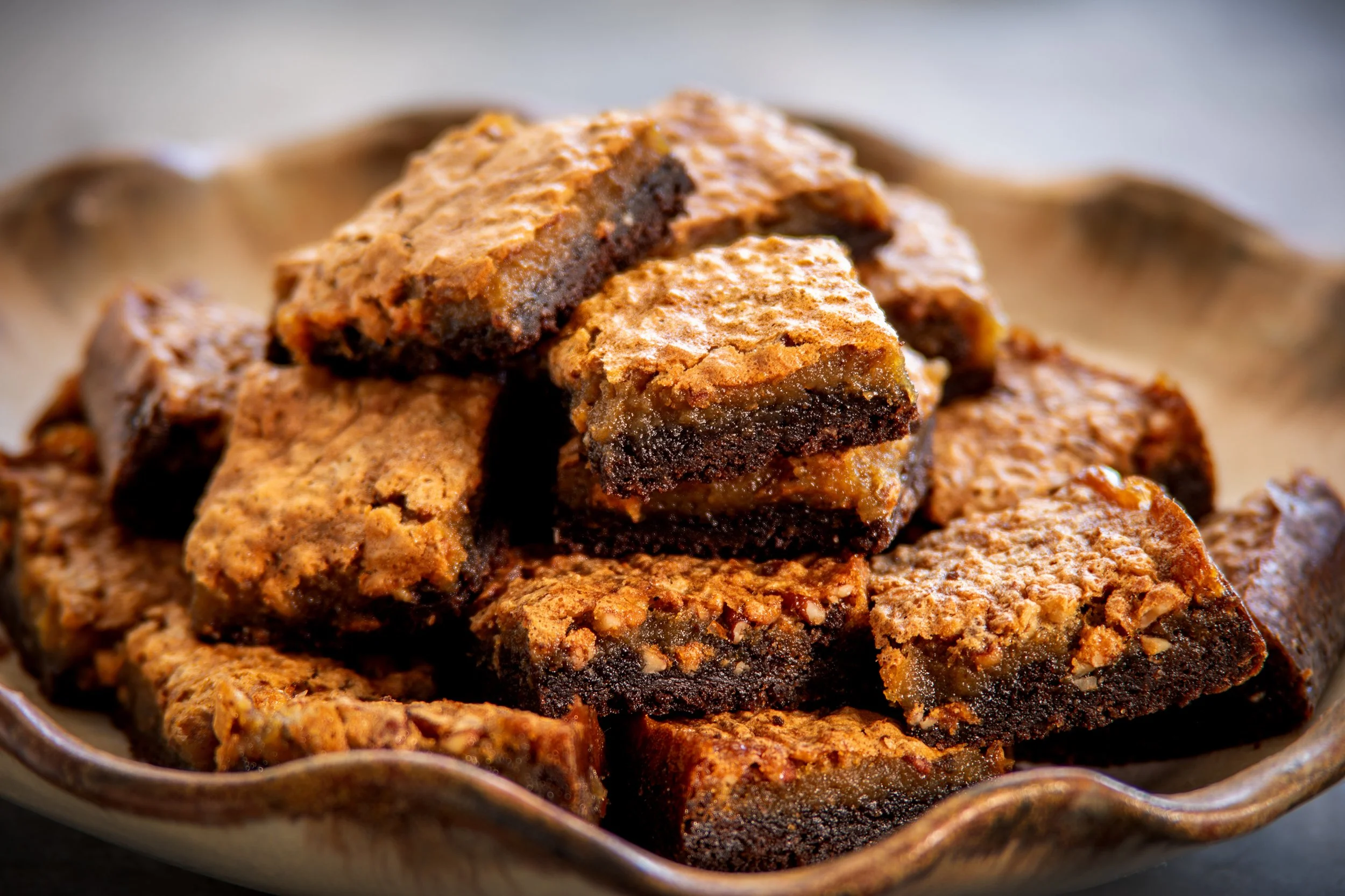 Browned Butter Pecan Bars cut and stacked on a pottery plate.