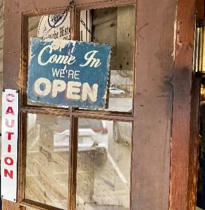 Worn, weathered, vintage sign reading "Come in. We're Open!"