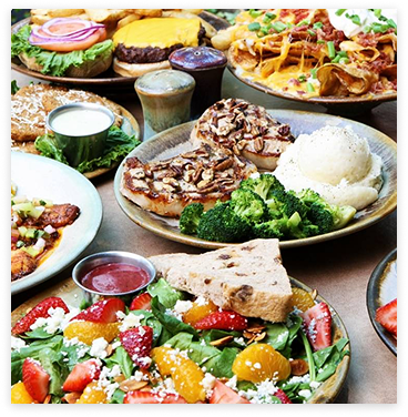 A tablescape of grilled chicken, hearty vegetables and fresh garden salads