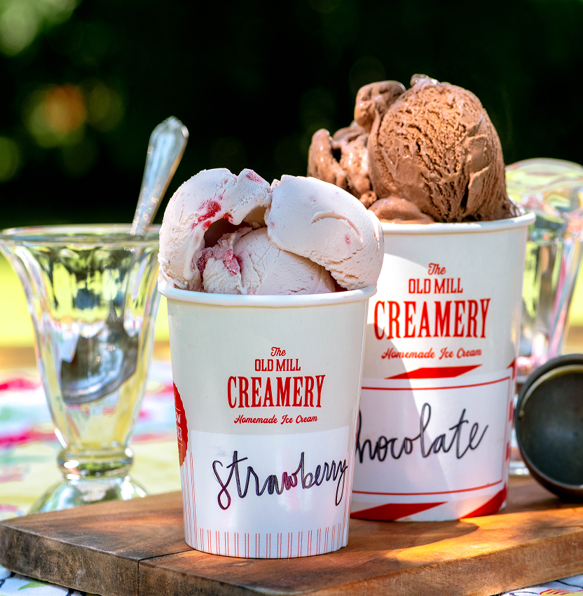 Close-up of freshly scooped strawberry and chocolate ice creams in cups at our Pigeon Forge shop.