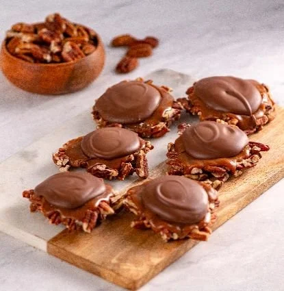 Our famous Bear Paws: sweet clusters of crunchy pecans and gooey caramel covered in smooth milk chocolate