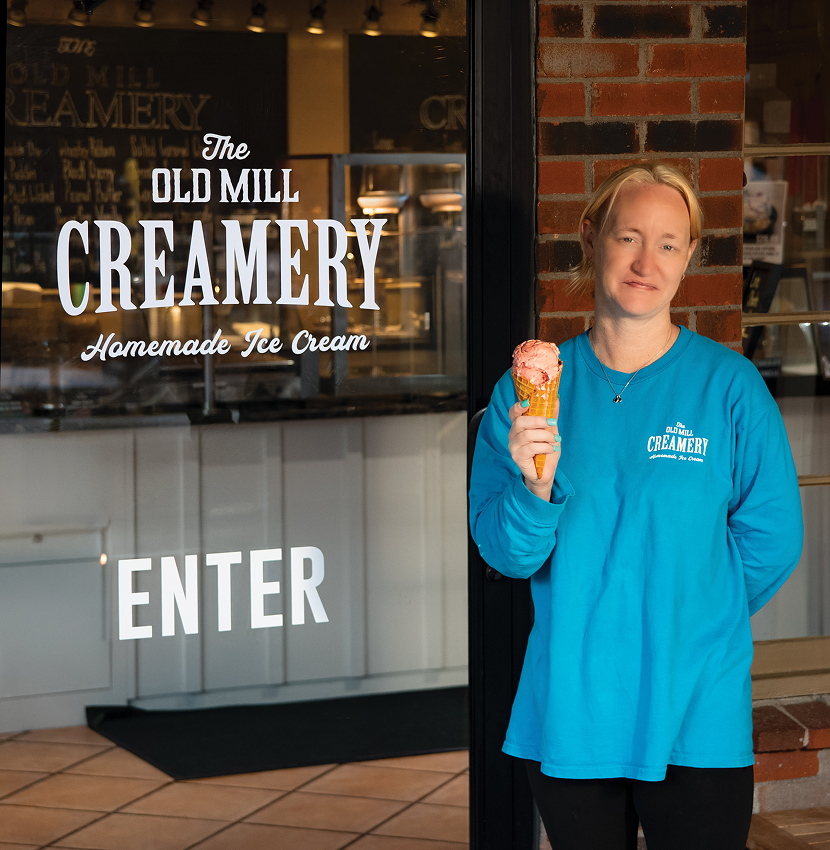 Customer holding waffle cone in front of The Old Mill Creamery