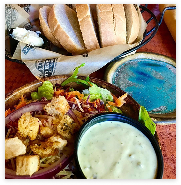 Closeup of a crisp garden salad and a basket of freshly baked bread