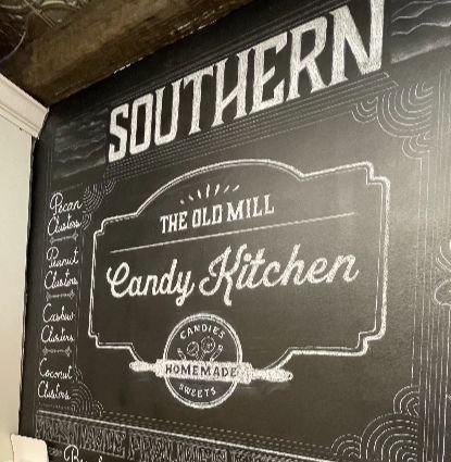 Chalk sign for The Old Mill Candy Kitchen known for homemade candies and sweets