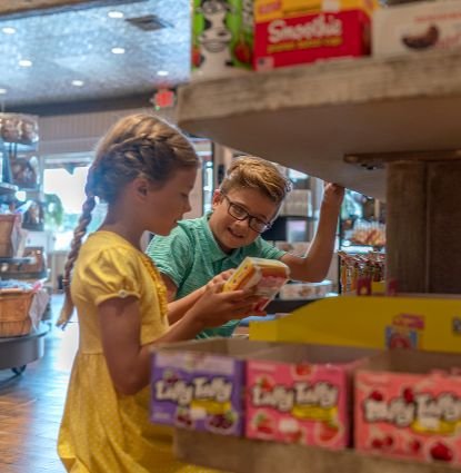 Two children giggle as they discover candy and treats