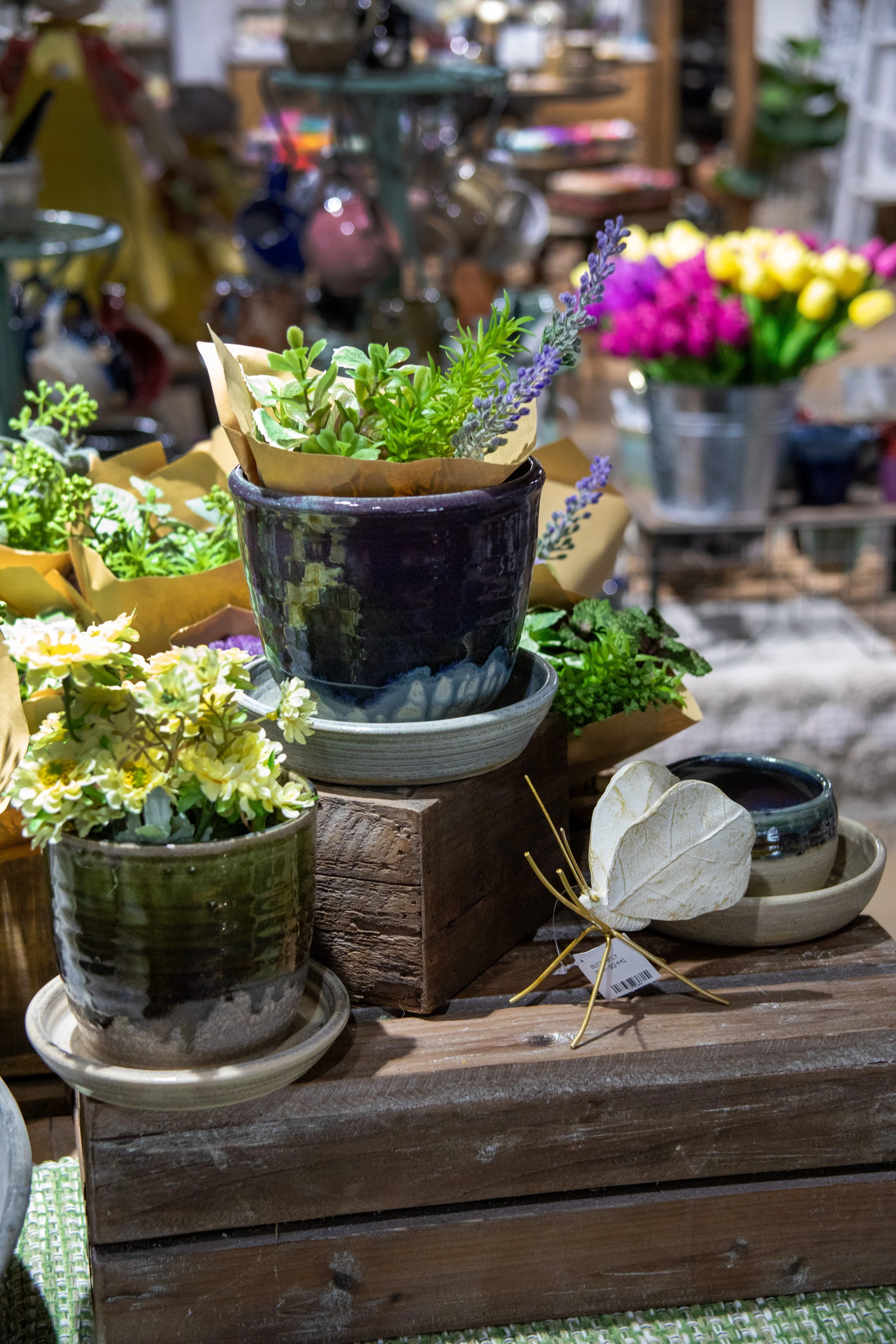 Assortment of small flowerpots filled with florals showcase the variety of our glazes