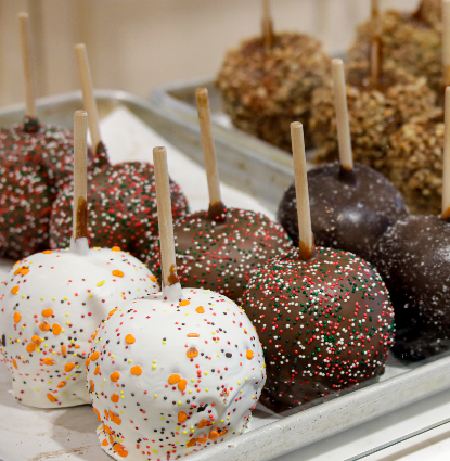 Rows of assorted cake pops flecked with colorful sprinkles