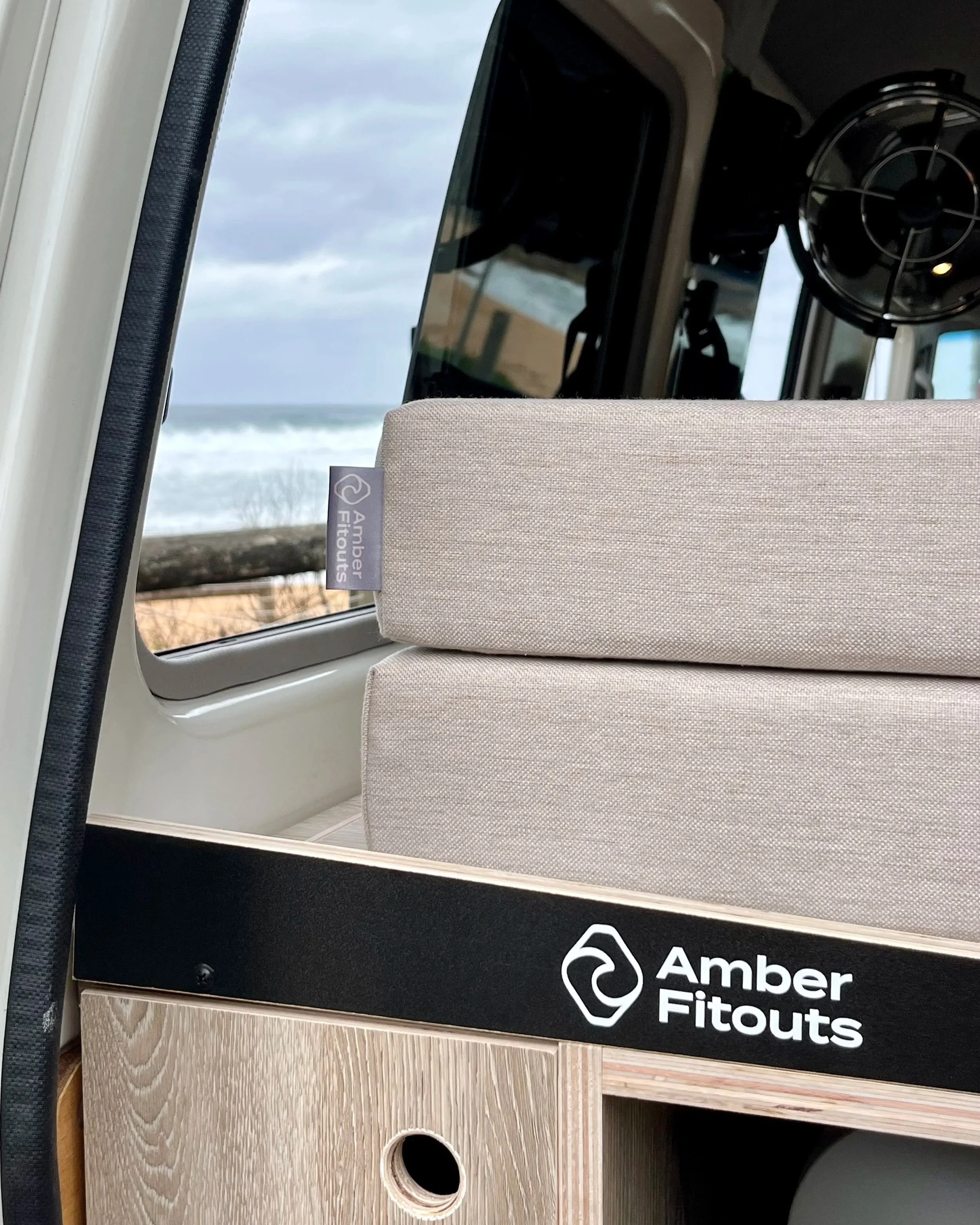 Close-up of Toyota Troopy campervan upholstery, custom cabinetry and Amber Fitouts branding