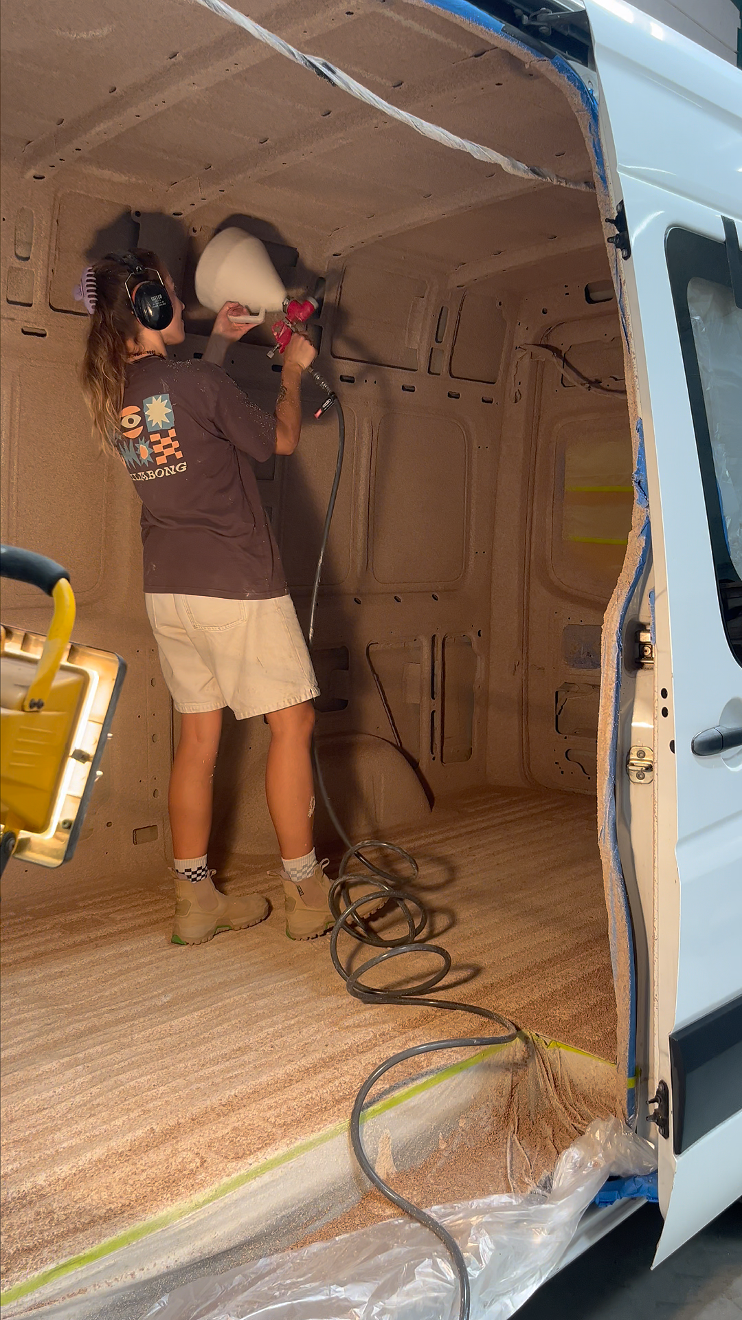 Spraying cork insulation inside Mercedes Sprinter campervan