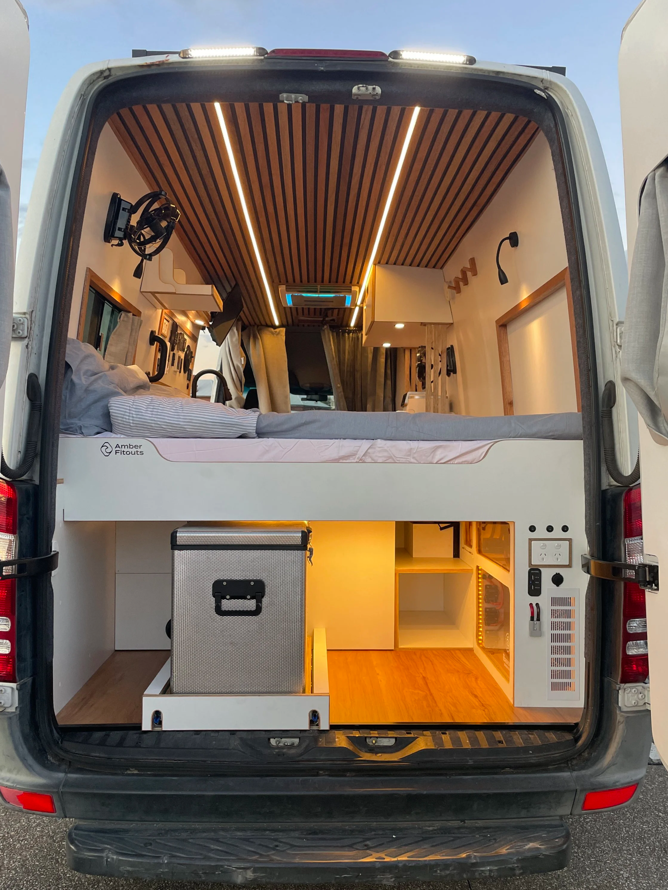 Mercedes Sprinter LWB campervan layout with bed, kitchen benches, sink and timber ceiling by Amber Fitouts.