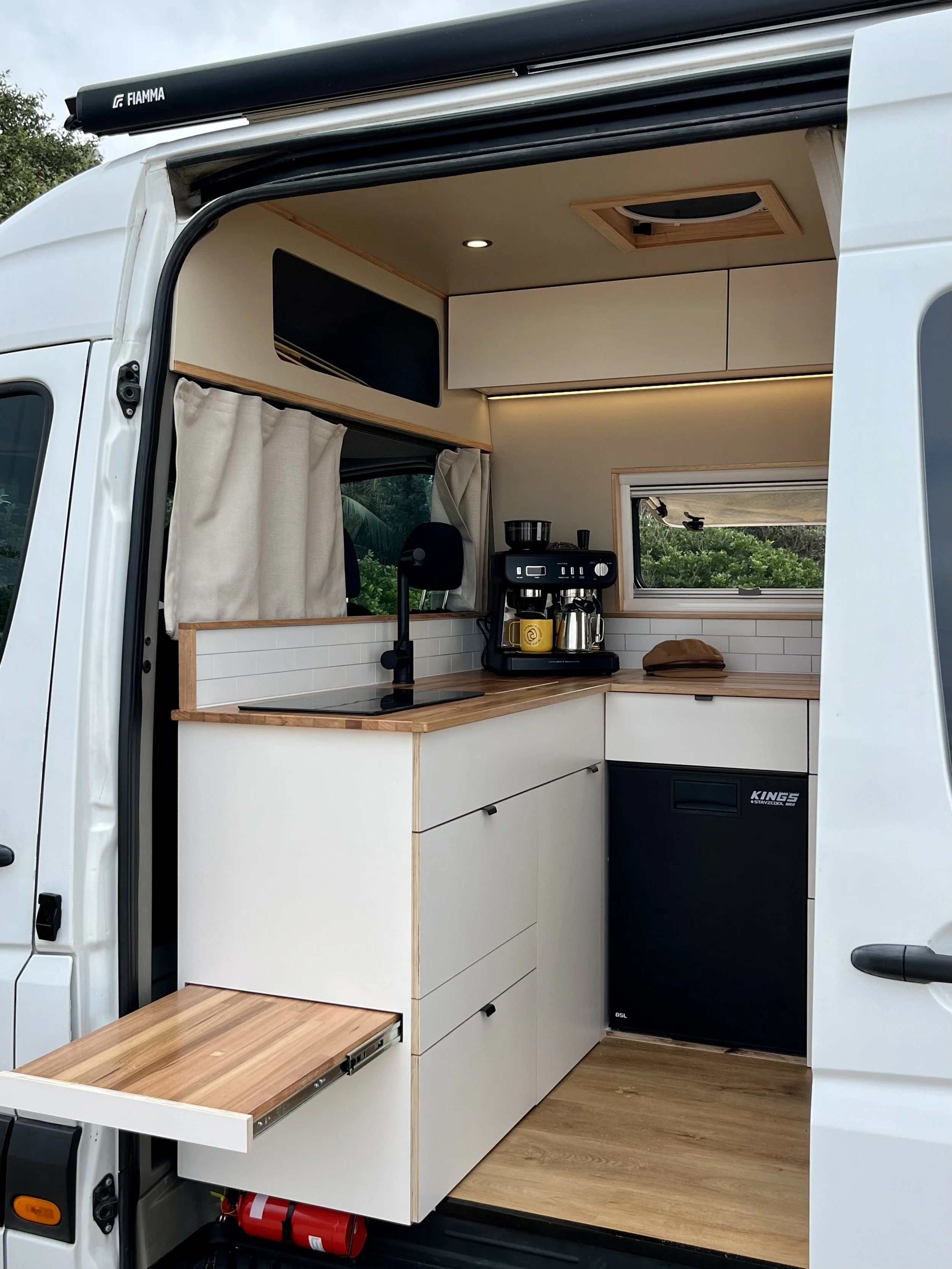 Mercedes Sprinter MWB High Roof campervan kitchen fitout with timber benchtop, fridge and pull-out bench