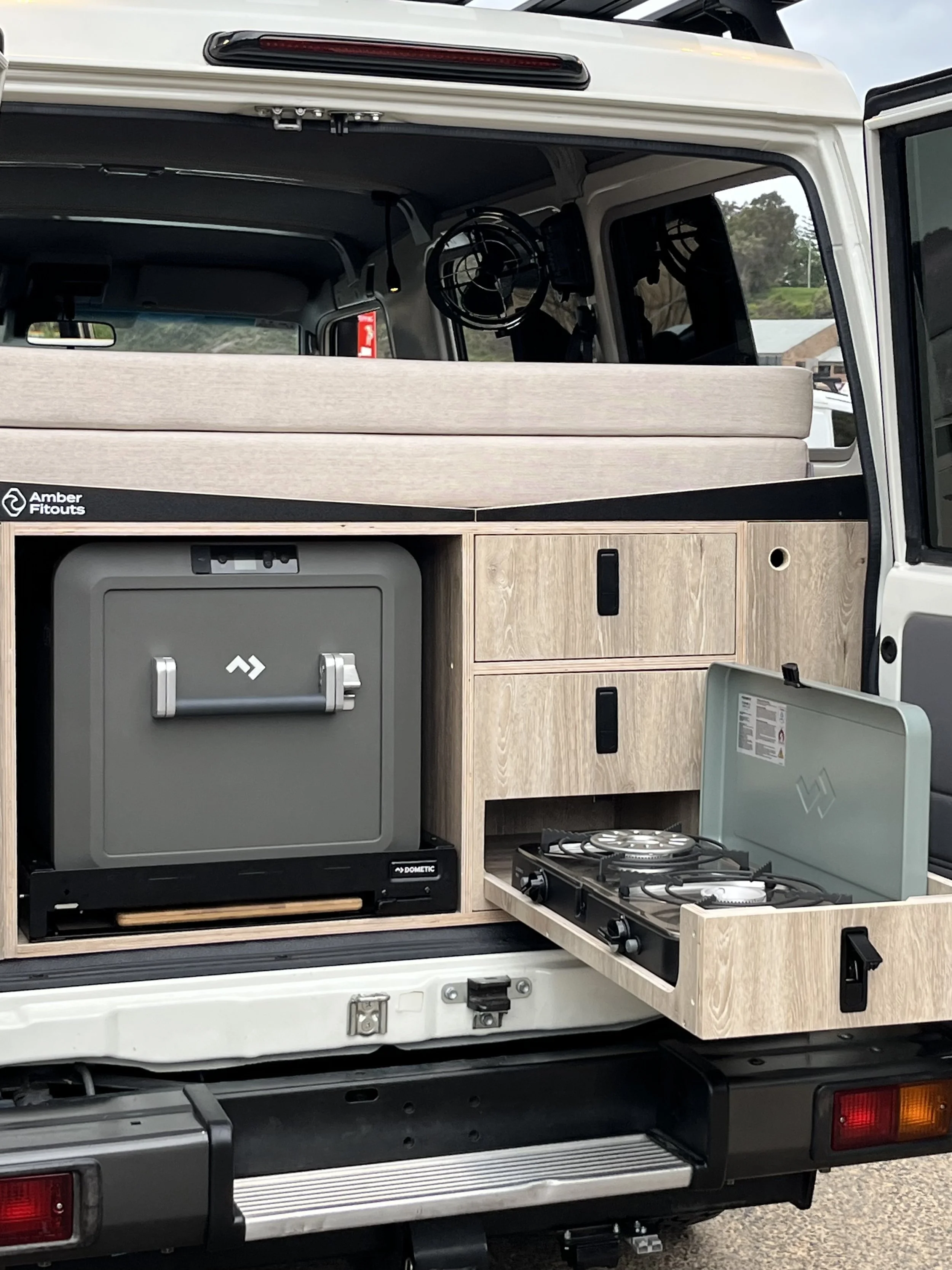 Toyota Landcruiser Troopcarrier camper conversion with rear kitchen storage, fridge slide and pull-out gas cooker.