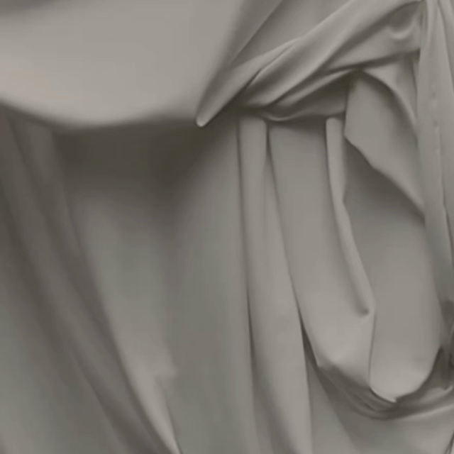 Close-up of a light-colored, possibly white or beige, fabric with folds and creases.