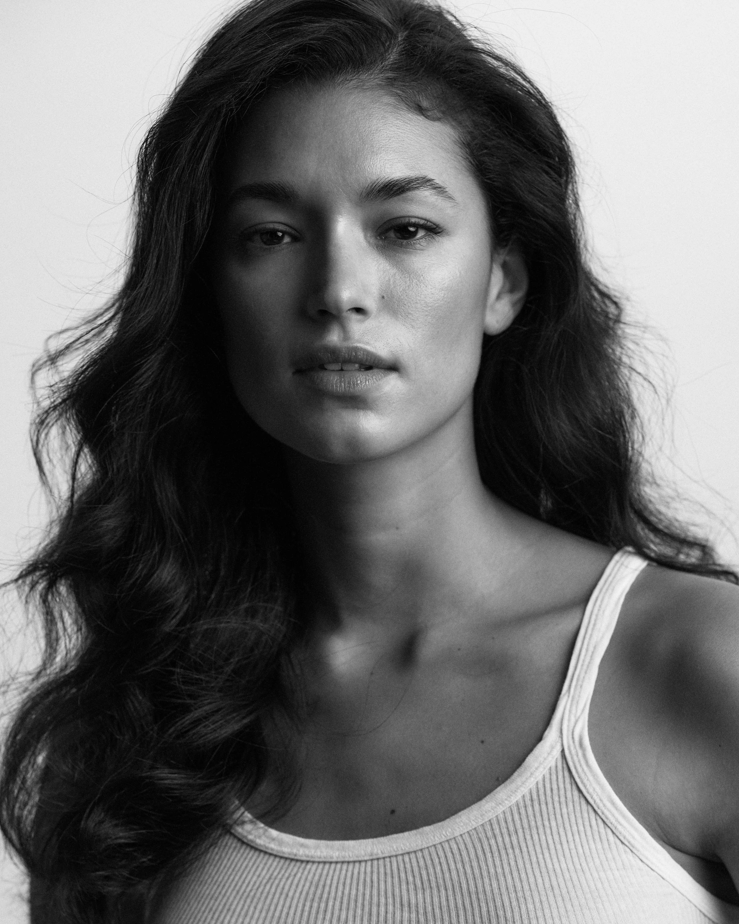 Black and white portrait of a woman in a white singlet top