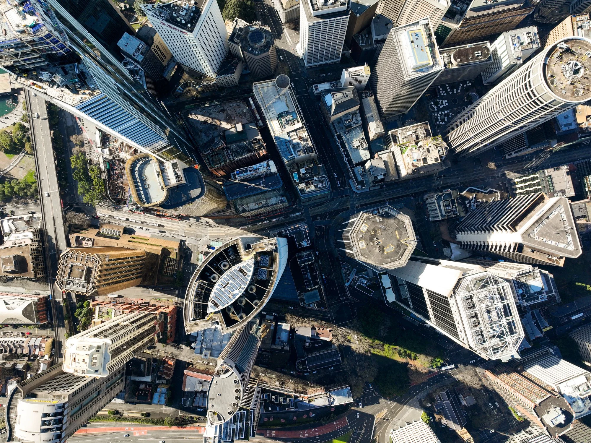 Aerial view of a dense cityscape with high-rise buildings, streets, and green spaces.