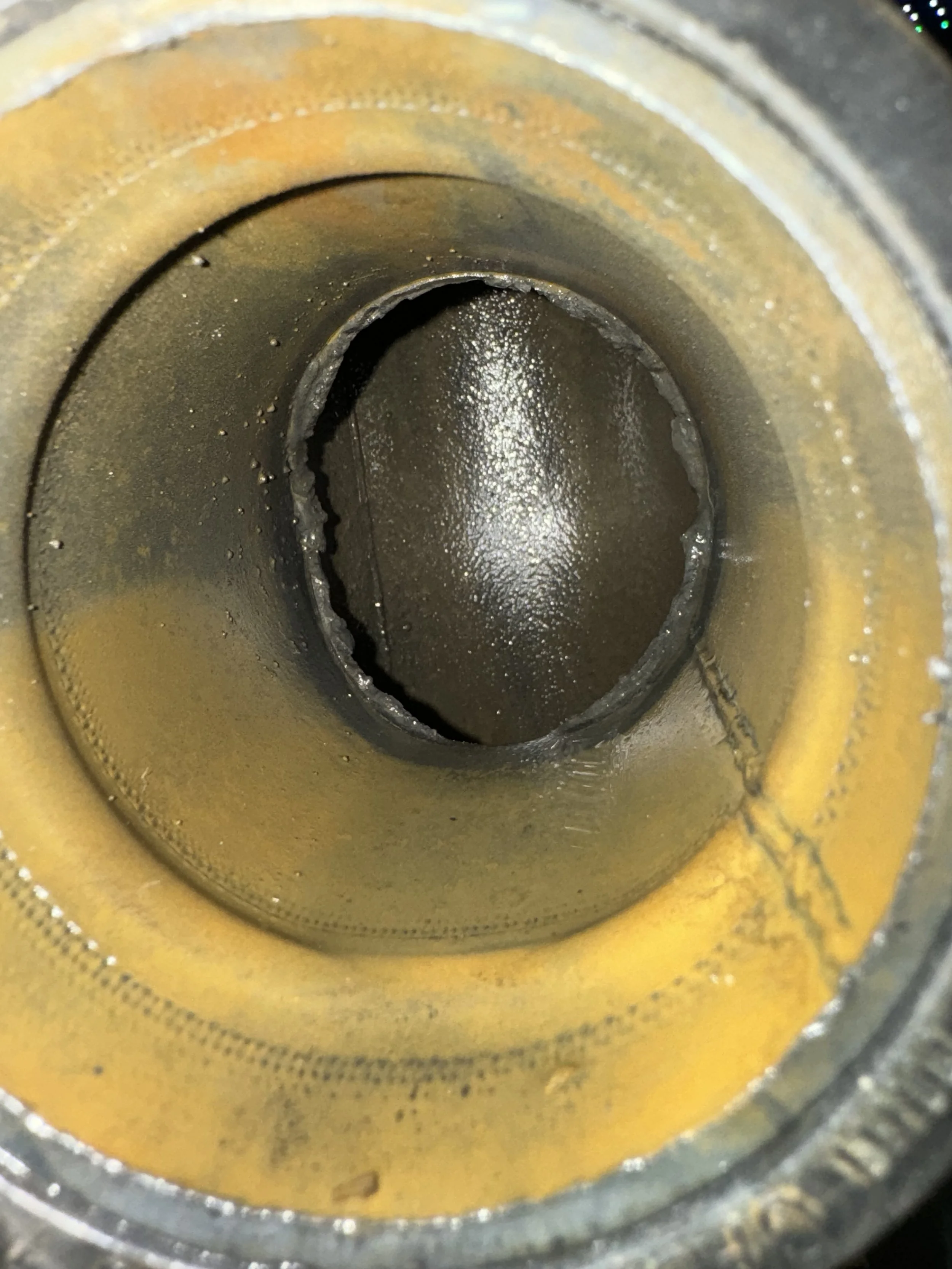 Close-up of a mechanical part's inner surface, showing wear and some metal corrosion.