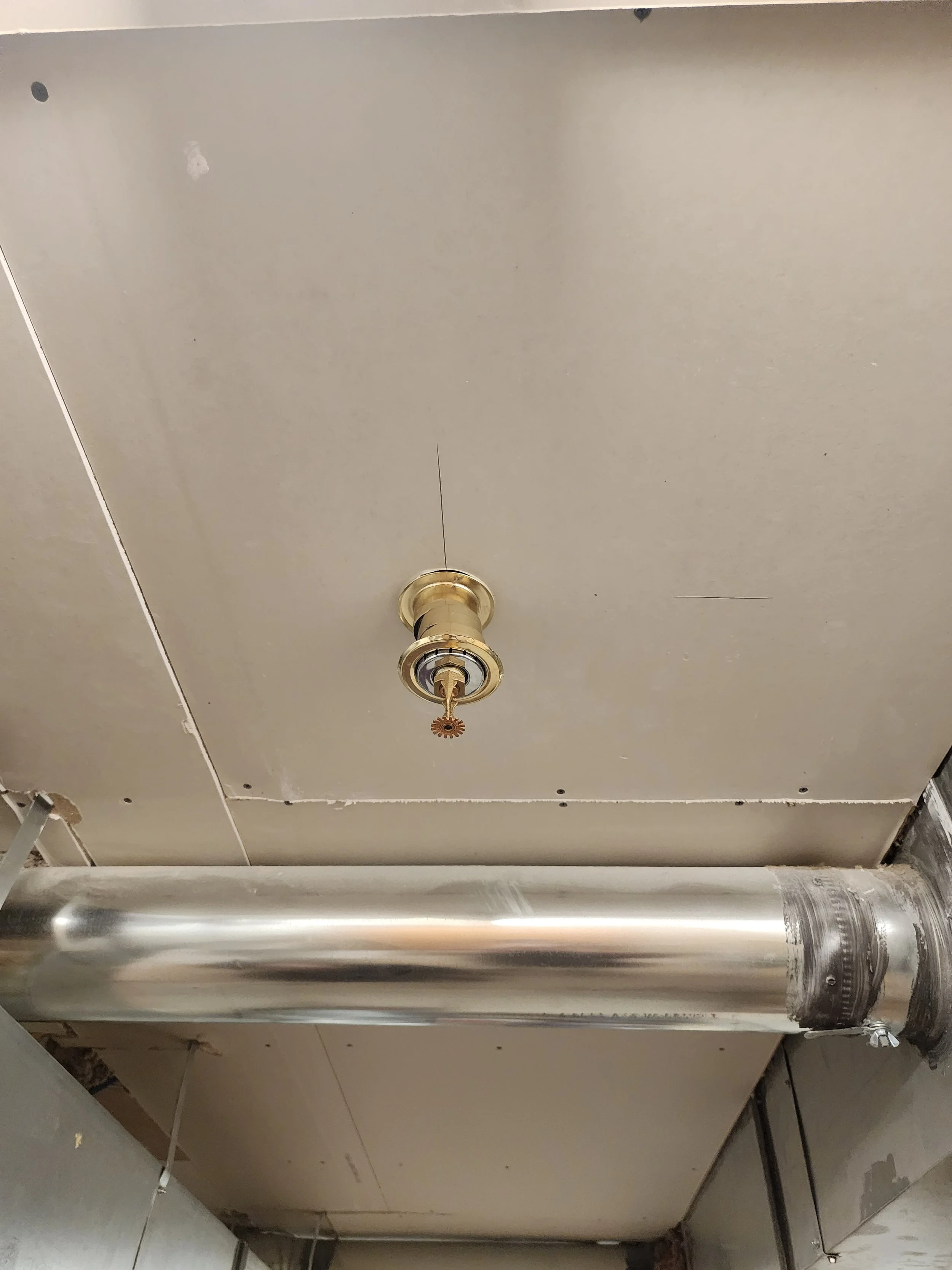 Ceiling with metal ductwork and a light fixture socket without a bulb.