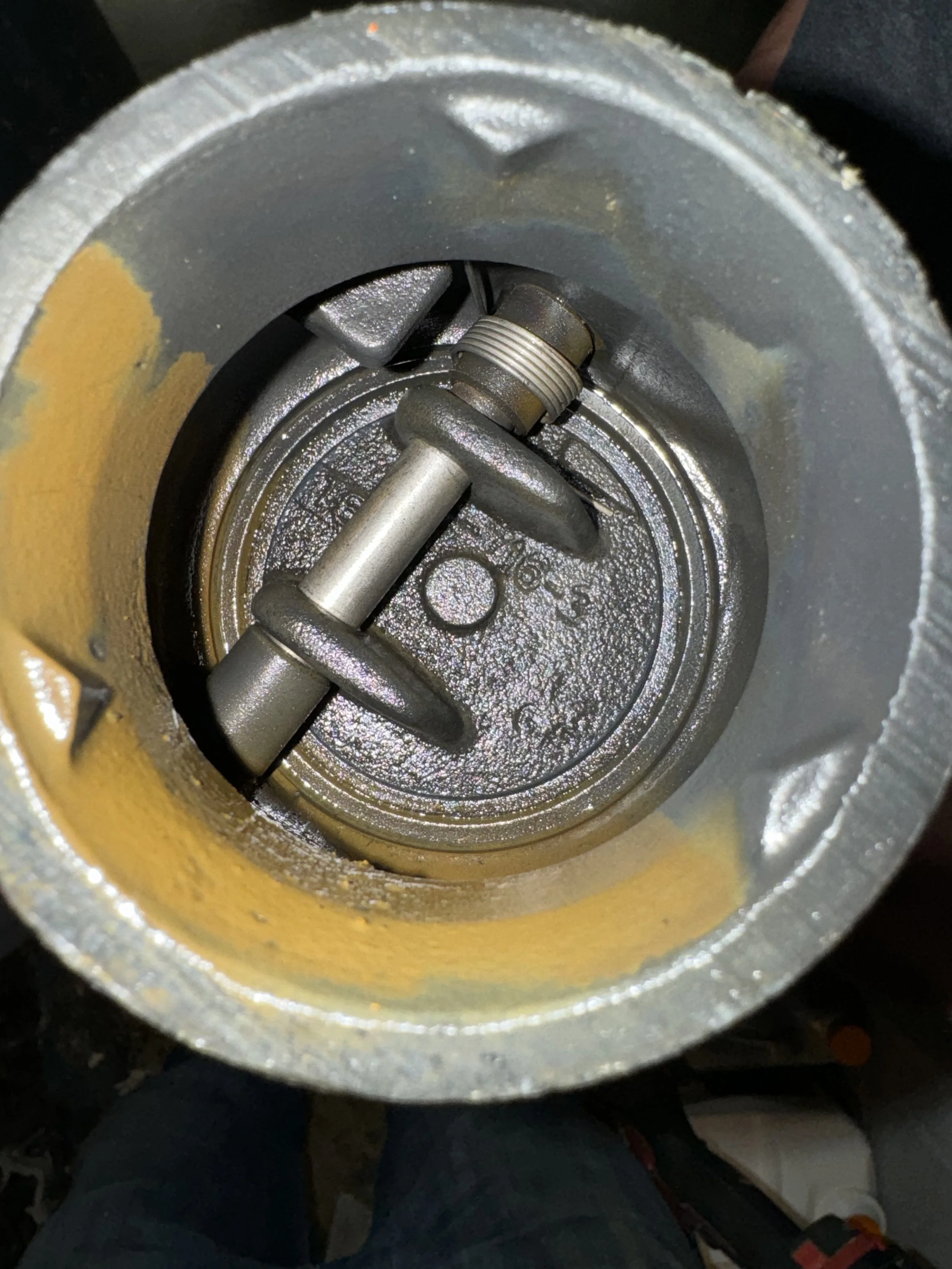 Close-up view of the inside of a metallic pipe or cylindrical mechanical component showing parts like screws and mechanical fittings.